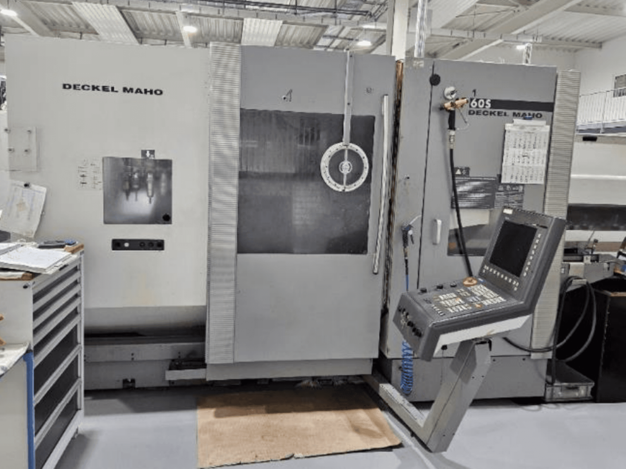 Etukuva DECKEL MAHO 60S CNC-koneesta ja ohjauspaneelista, työkalut näkyvissä, työpajassa.