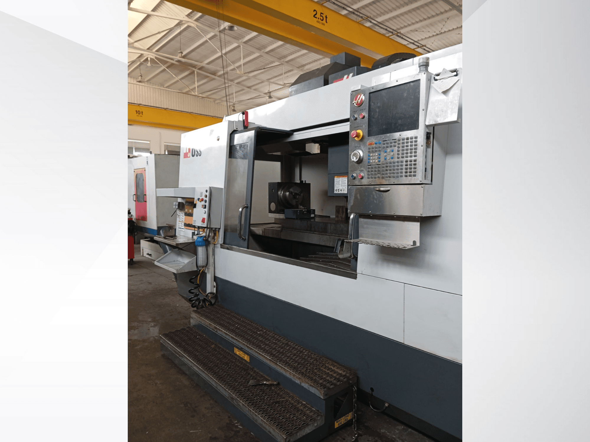 Haas CNC-jyrsinkone, etukuva, jossa näkyy ohjauspaneeli, työskentelyalue ja yksityiskohtaiset portaat.