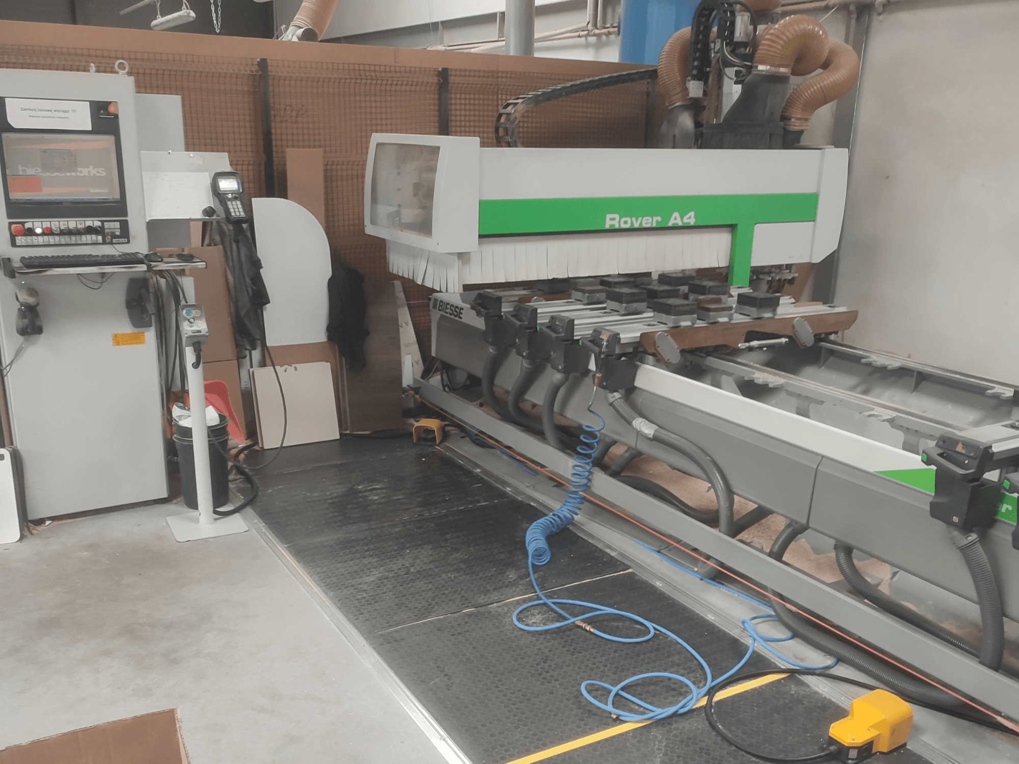 BIESSE Rover A4 CNC-puunkäsittelykeskus sivulta katsottuna; kuvassa näkyvät ohjauspaneeli, alipainekiinnikkeet ja pölynpoistojärjestelmä.