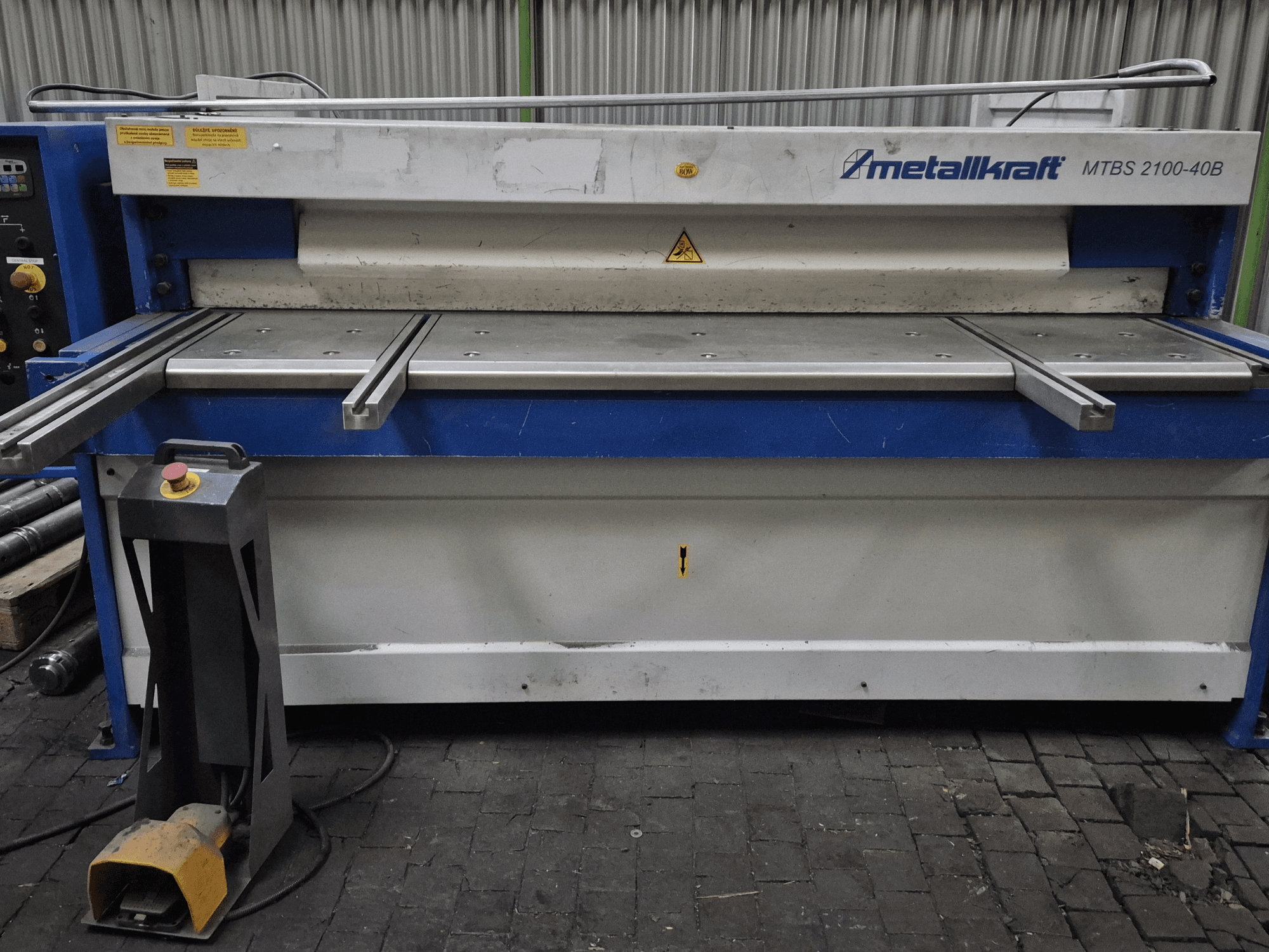 CNC-leikkauskone Metallkraft MTBS 2100-40B, etukuva, jossa on ohjauspaneeli ja leikkuupöytä, jossa on turvaominaisuudet.