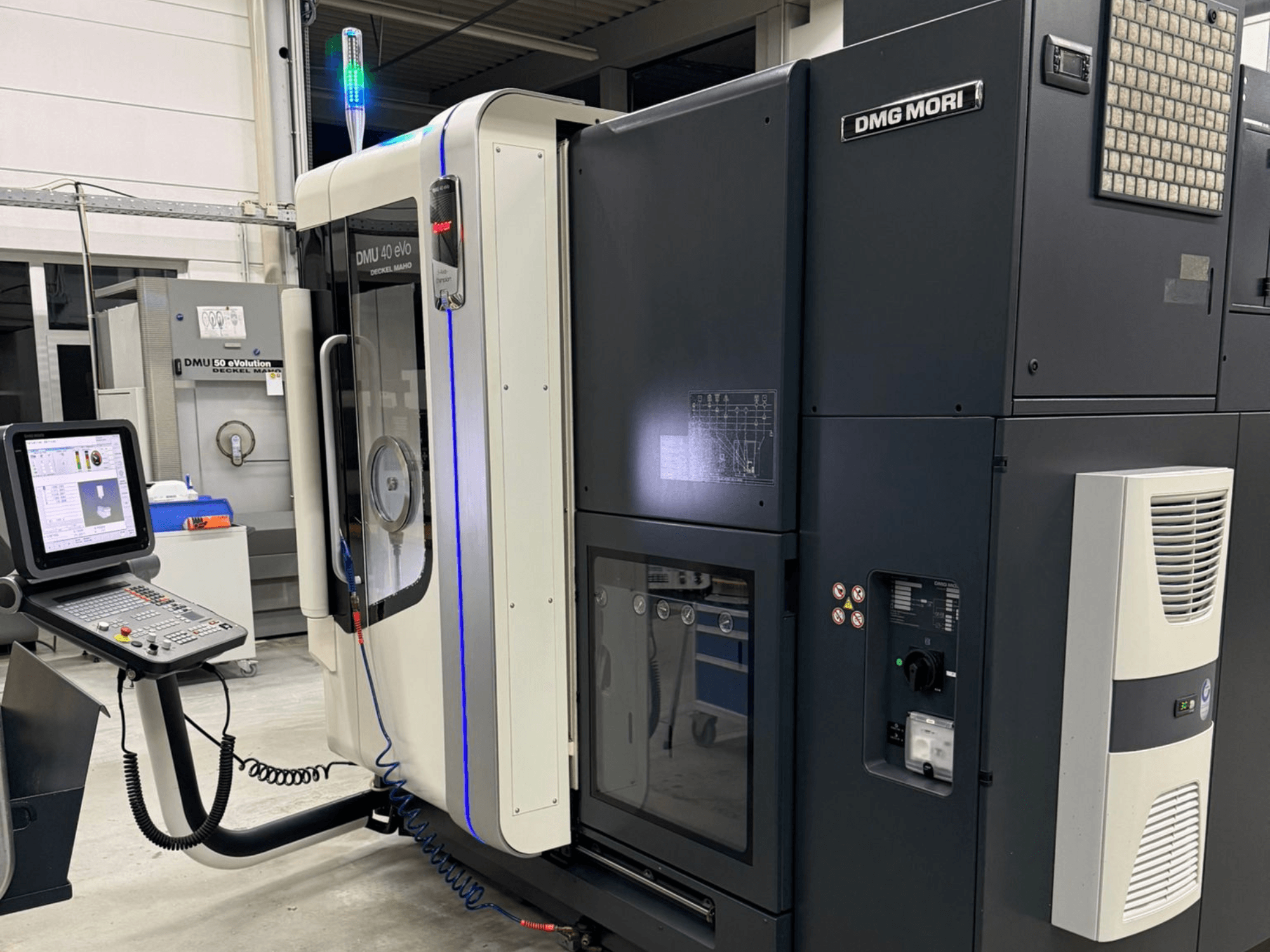 DMG MORI DMU 40 eVo -kone, etukuva, jossa näkyvät hallintalaitteet, LED-merkkivalot ja tyylikäs muotoilu, jossa korostuvat teolliset ominaisuudet.
