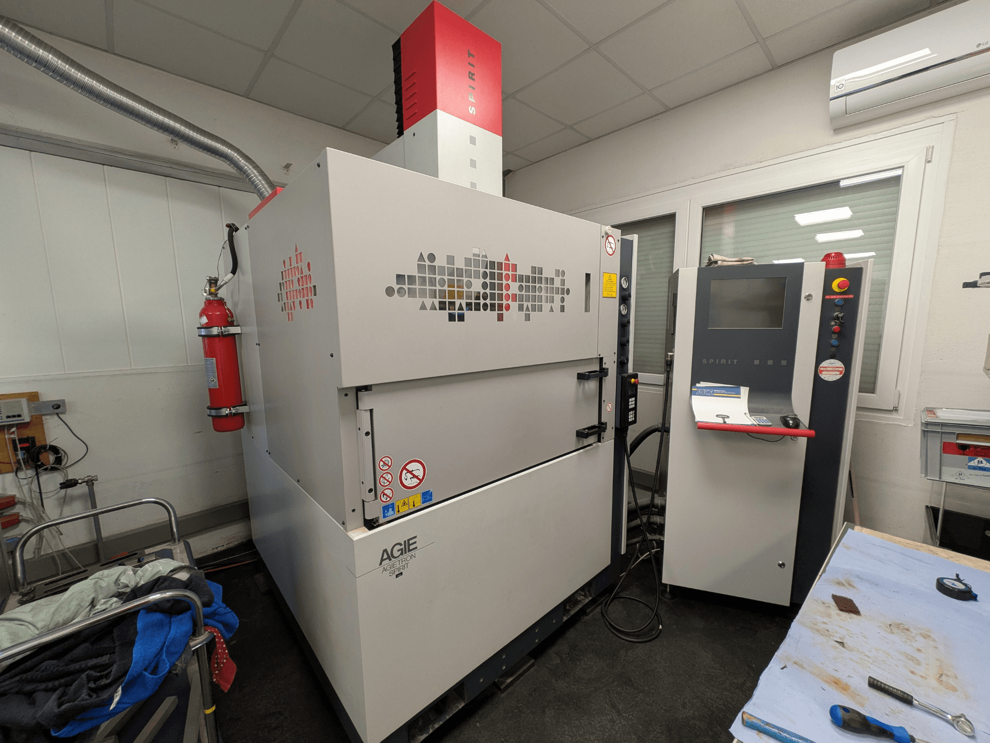 Senkkipuristussyöstökone AGIE AGIETRON SPIRIT 3, sivukuva, jossa näkyy ohjauspaneeli ja palosammutin.