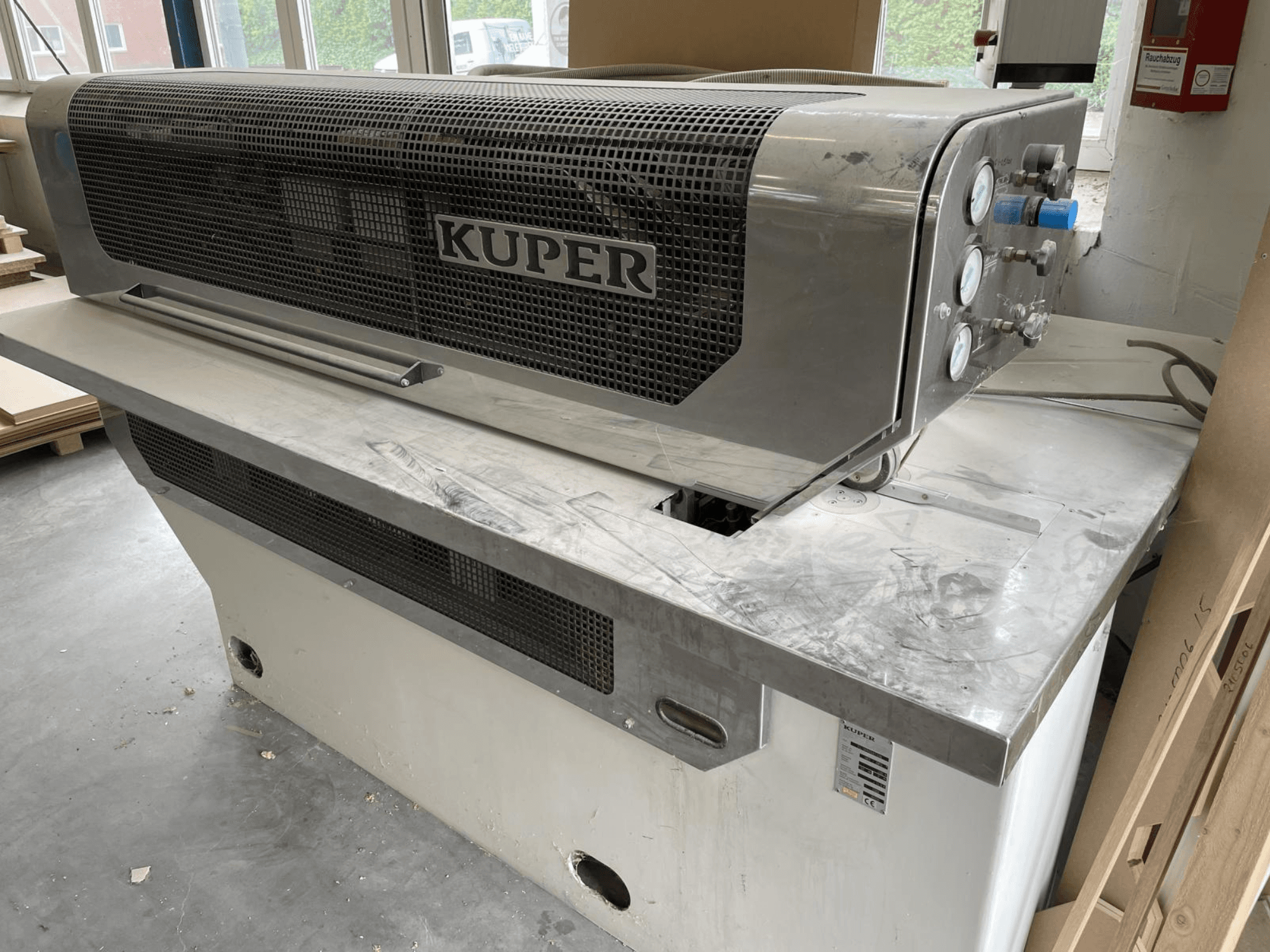 Viilugiljotiini KUPER FLI, etukuva, jossa on ruostumattomasta teräksestä valmistettu runko, mittarit ja puhdas leikkausalue työpöydällä.