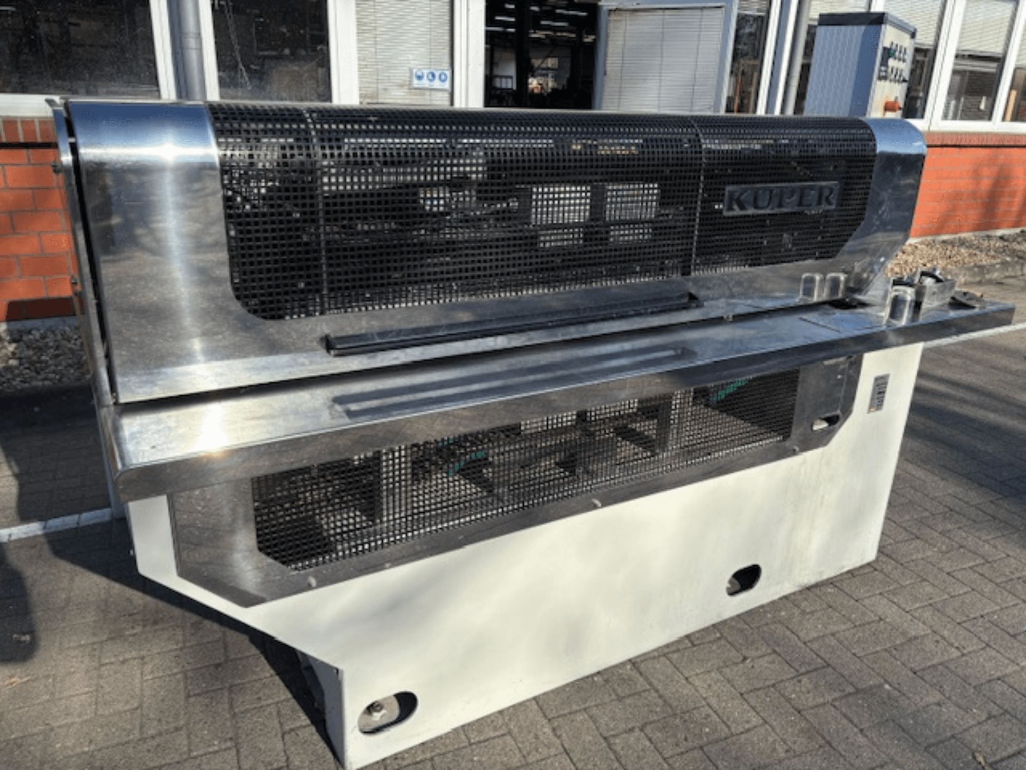 KUPER FLI -viiluhylly, etukuva, jossa on ruostumattomasta teräksestä valmistettu runko ja suojaverkko turvallista käyttöä varten.