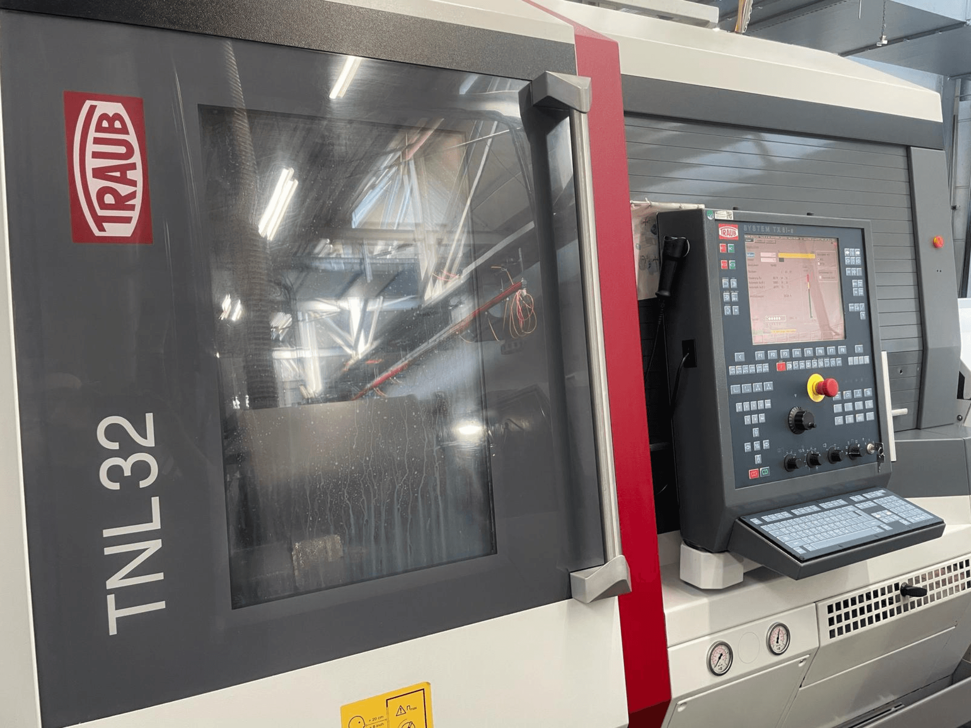 Traub TNL32 CNC-sorvin etukuva, jossa on ohjauspaneeli painikkeineen, näyttö ja tyylikäs metallikotelo.