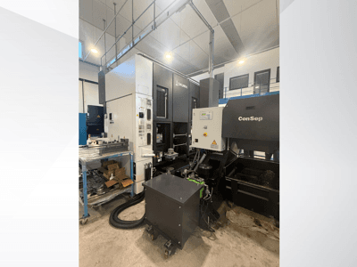 Okuma-työstökeskus ConSep-yksiköllä, sivukuva, jossa näkyy hallintalaitteet ja teollisuusasetukset, mukaan lukien metallilastusäiliö.