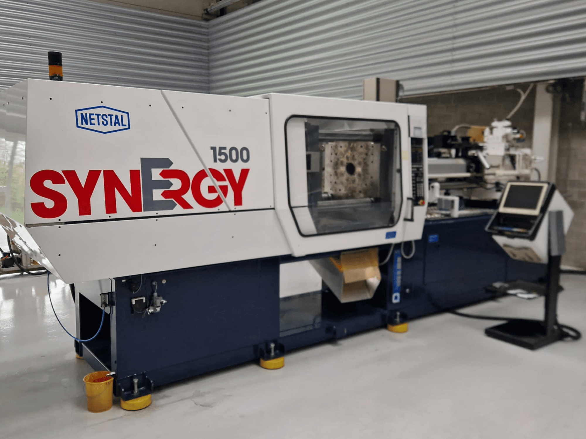 Netstal Synergy 1500-460 hydraulinen ruiskuvalukone, etukuva, jossa näkyy ohjauspaneeli ja avoin ruiskutusalue.