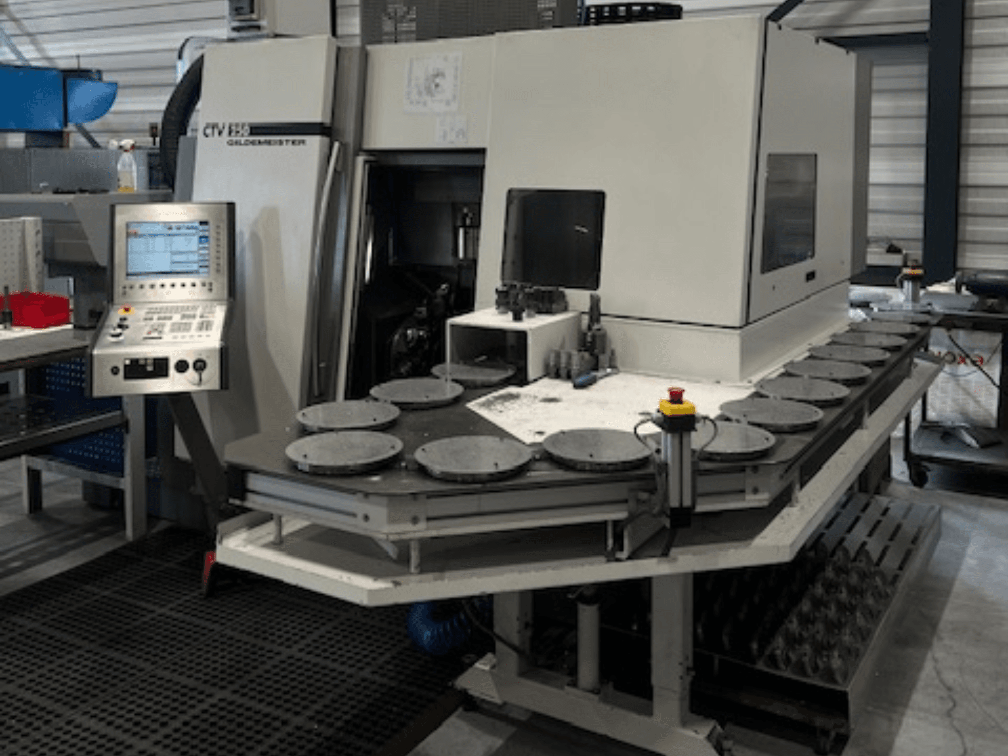 Alt-teksti: CTV E33 Goldmeister-työstöyksikkö työpajassa, etukuva, jossa on ohjauspaneeli ja useita pyöreitä työtasoja.