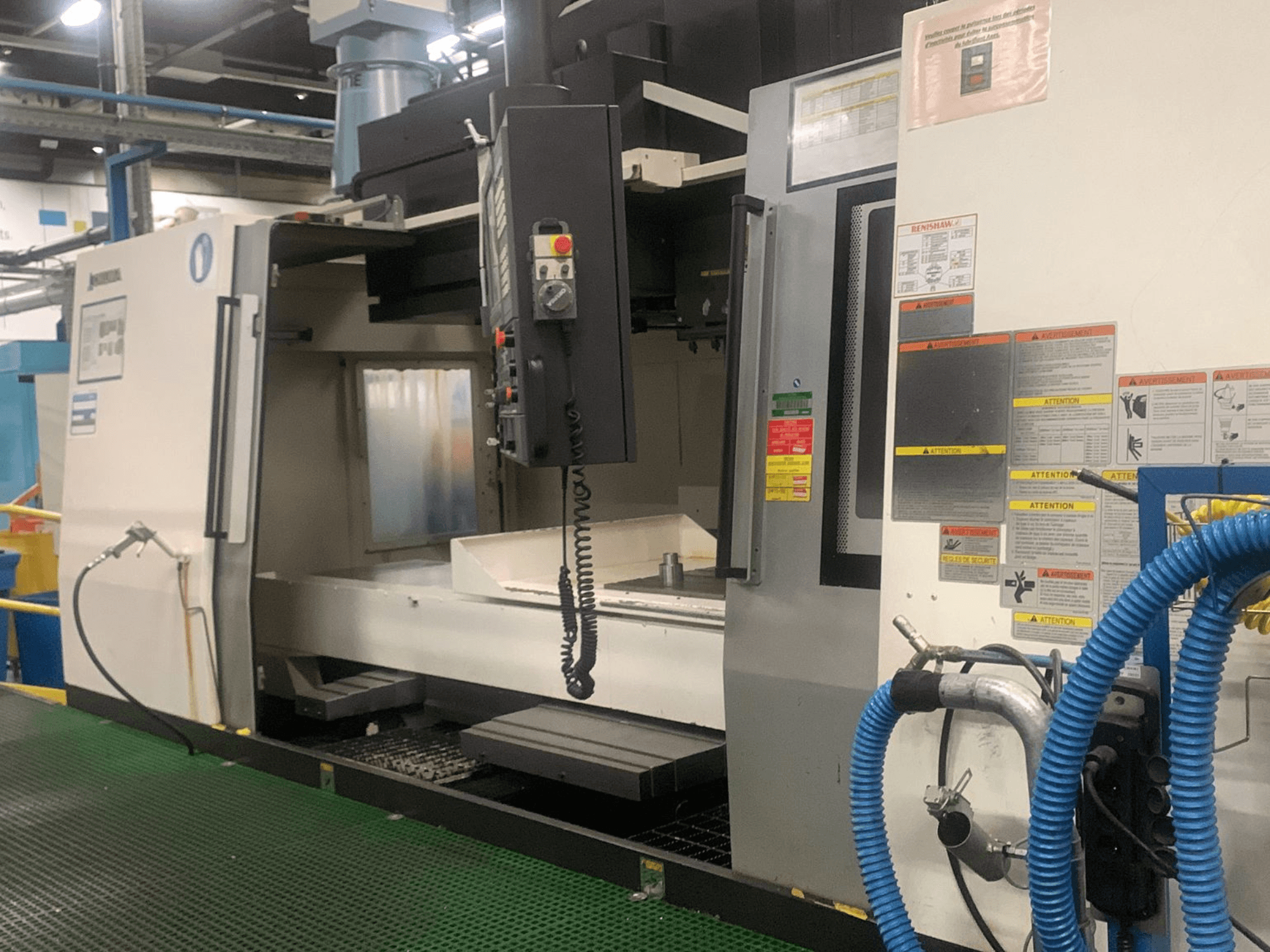 Okuma Millac 852 VII -pystykoneistuskeskus, etunäkymä, jossa näkyvät ohjauspaneeli, karan alue ja turvallisuusmerkinnät.