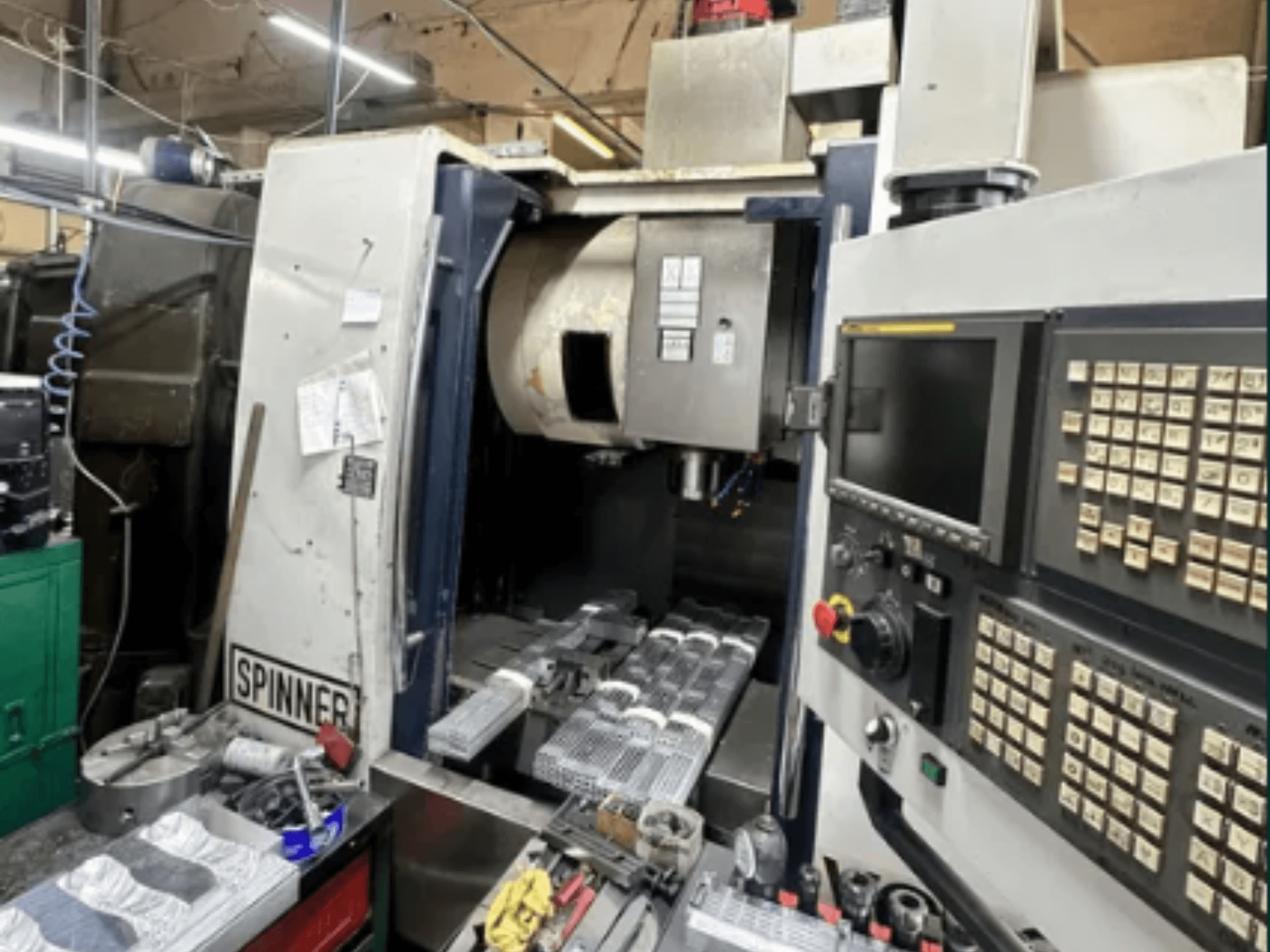 Spinnerin CNC-kone, etukuva; siinä on kosketusnäytön käyttöliittymä, työkalut työtilassa ja työstetyt osat valmiina työstöä varten.