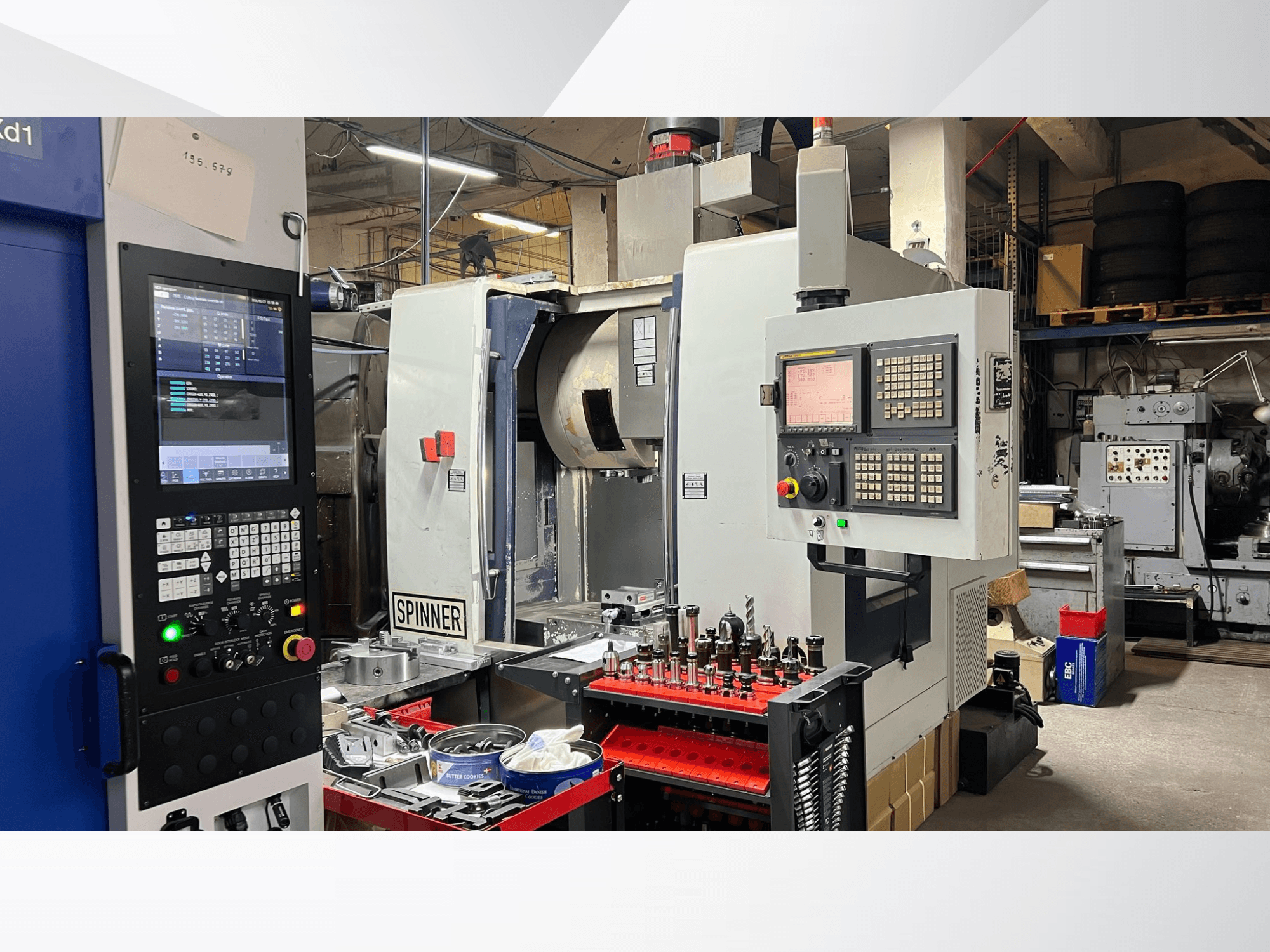 CNC-kone, jonka ohjauspaneeli, työkalut ja työkappaleet ovat näkyvissä, etukulmasta katsottuna työpajaympäristössä.