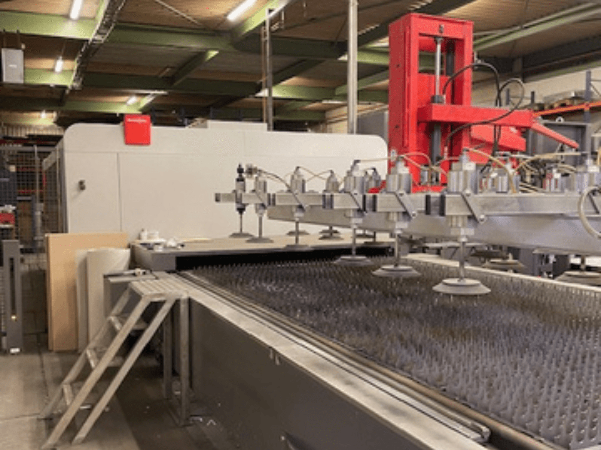 Bystronic BySprint Fiber 4020 Fiber 4Kw kuitulaserleikkauskoneen etukuva, jossa on suuttimet ja leikkuualusta.