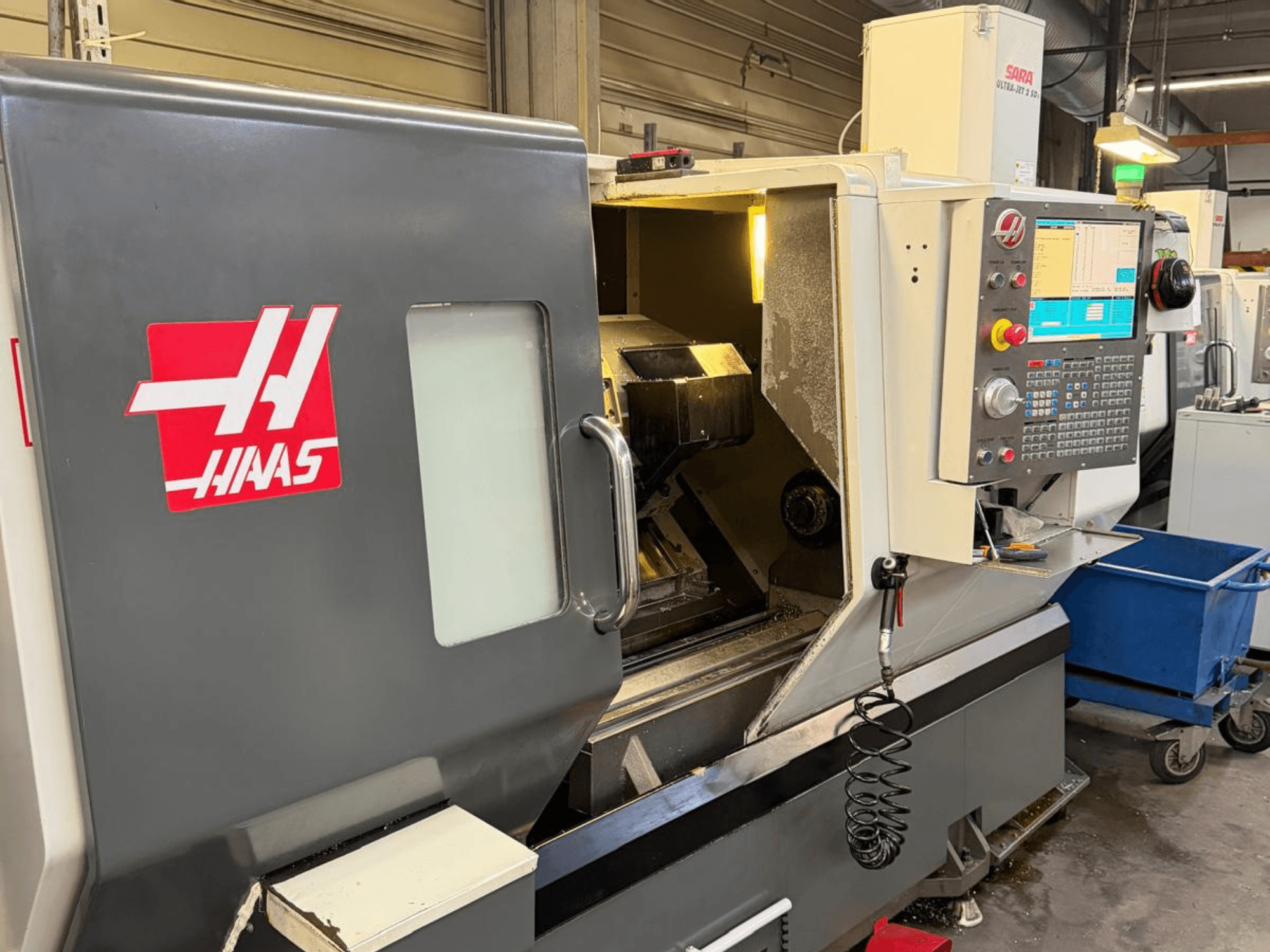 HAAS DS-30SSY vaakasuuntainen sorvauskone, etukuva, jossa ohjauspaneeli ja sisäiset komponentit näkyvissä, korjaamolla.