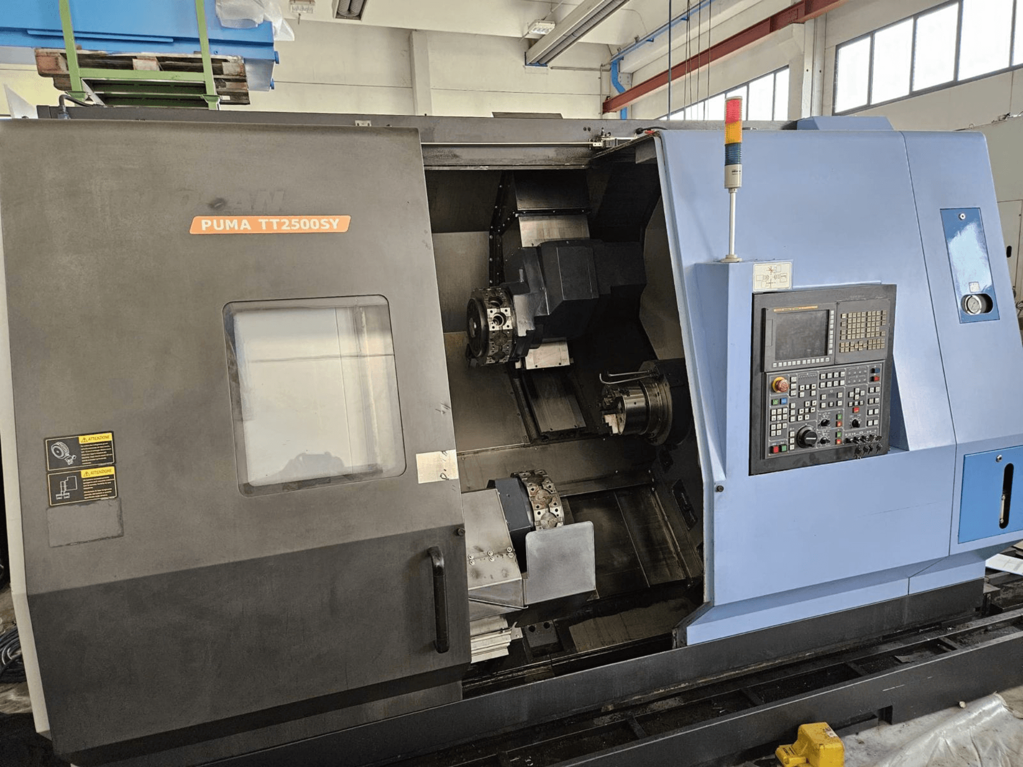 DOOSAN PUMA TT2500SY -monikara-sorvi, etunäkymä, jossa näkyvät ohjauspaneeli ja koneen sisätilojen yksityiskohdat.