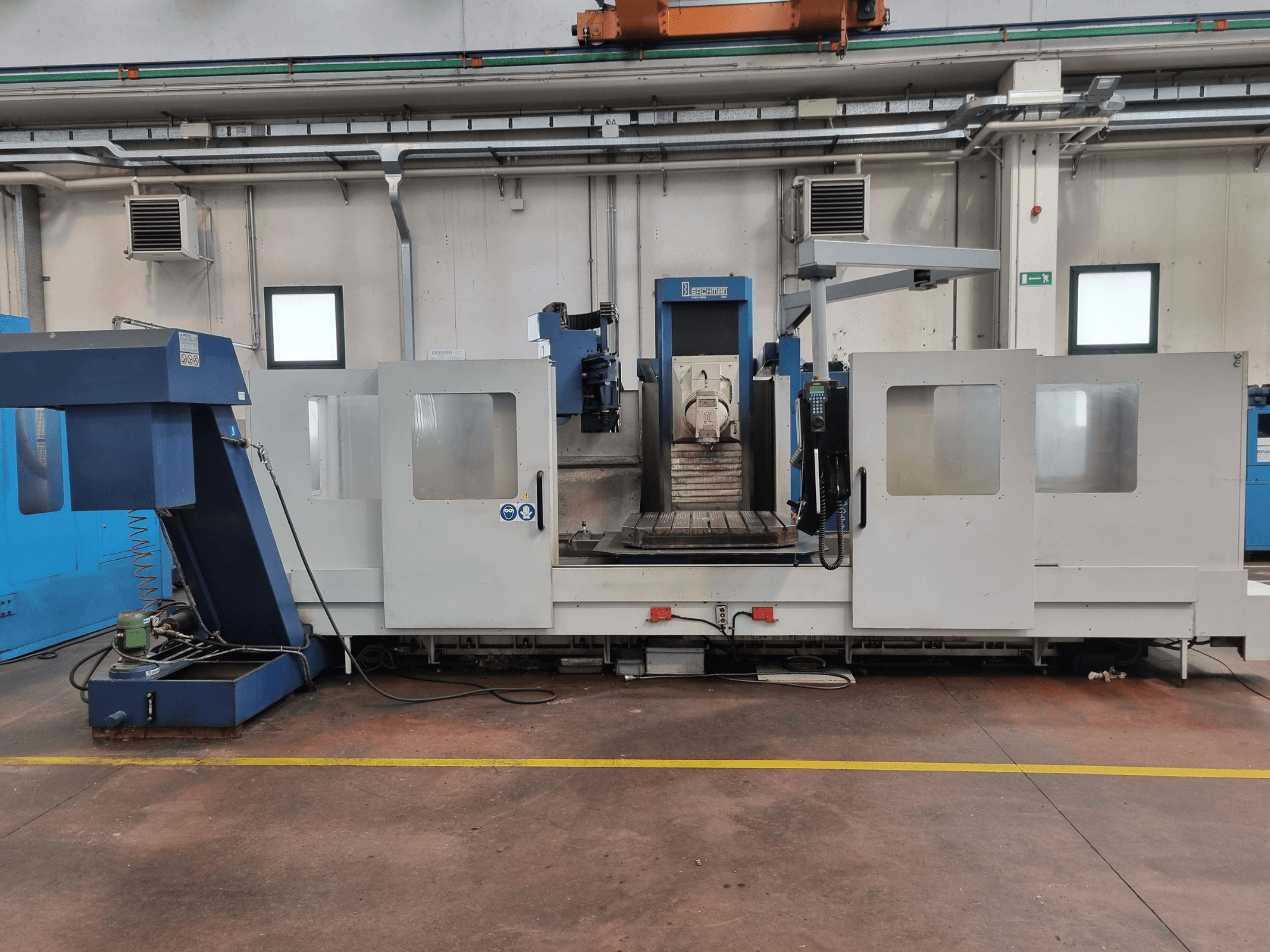 CNC-jyrsin "Brembana", sivukuva, jossa näkyy ohjauspaneeli ja työskentelyalue, jonka sisällä on työpöytä.