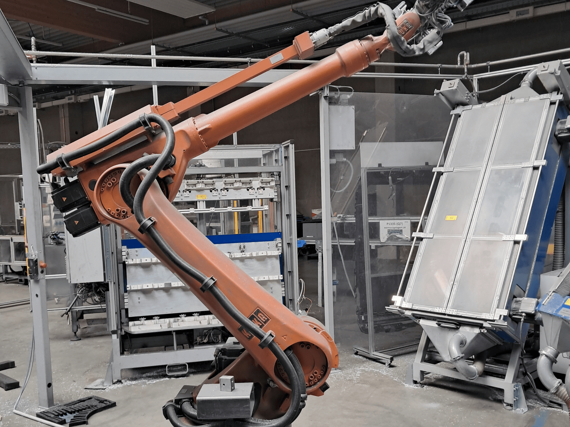 KUKA KR 30L16-2 -robottivarsi tehdasympäristössä, sivukuva, jossa näkyvät kaapelit ja mekaaniset komponentit.