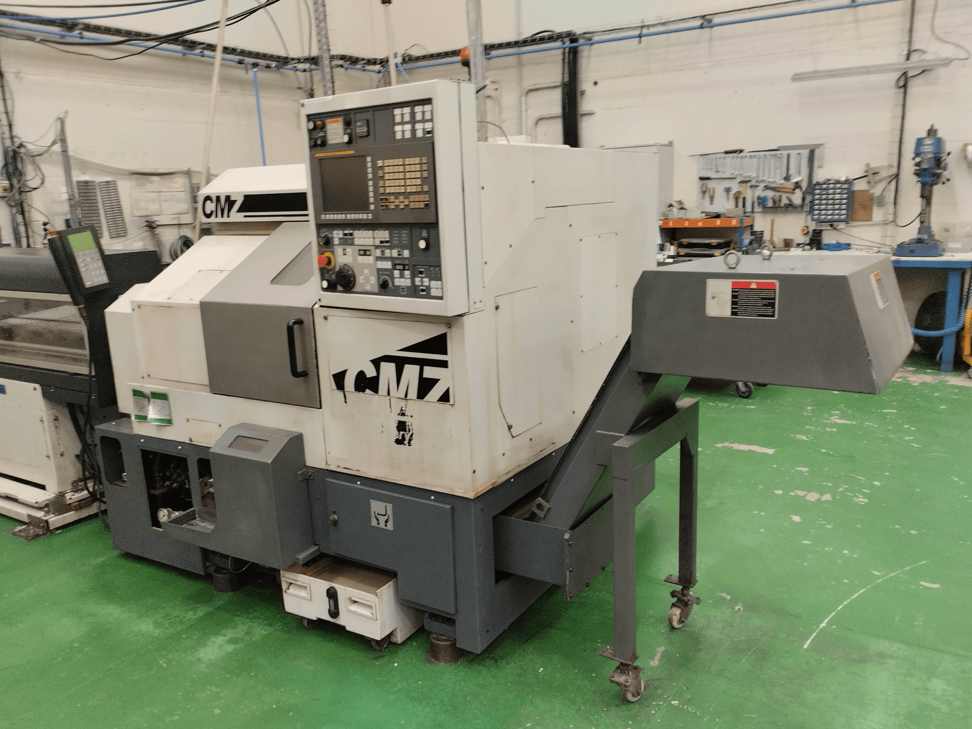 CMZ TB-67M sorvausjyrsinkeskus etukuvassa, jossa on ohjauspaneeli ja syöttömekanismi, asetettu työpajaympäristöön.