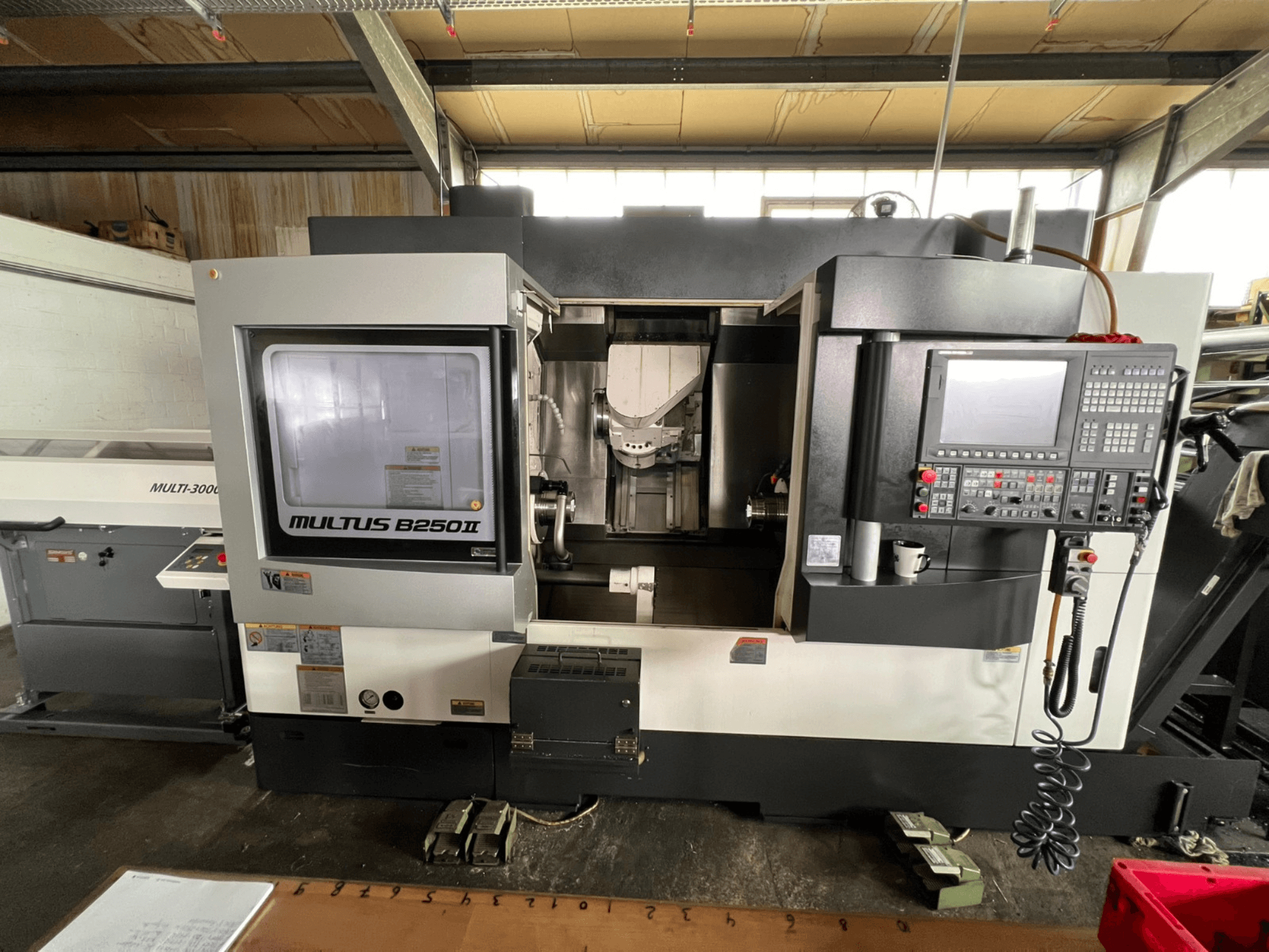 Okuma Multus B250II MW -sorvaus-jyrsinkeskus, etunäkymä, jossa näkyvät ohjauspaneelin ja työstöalueen yksityiskohdat.