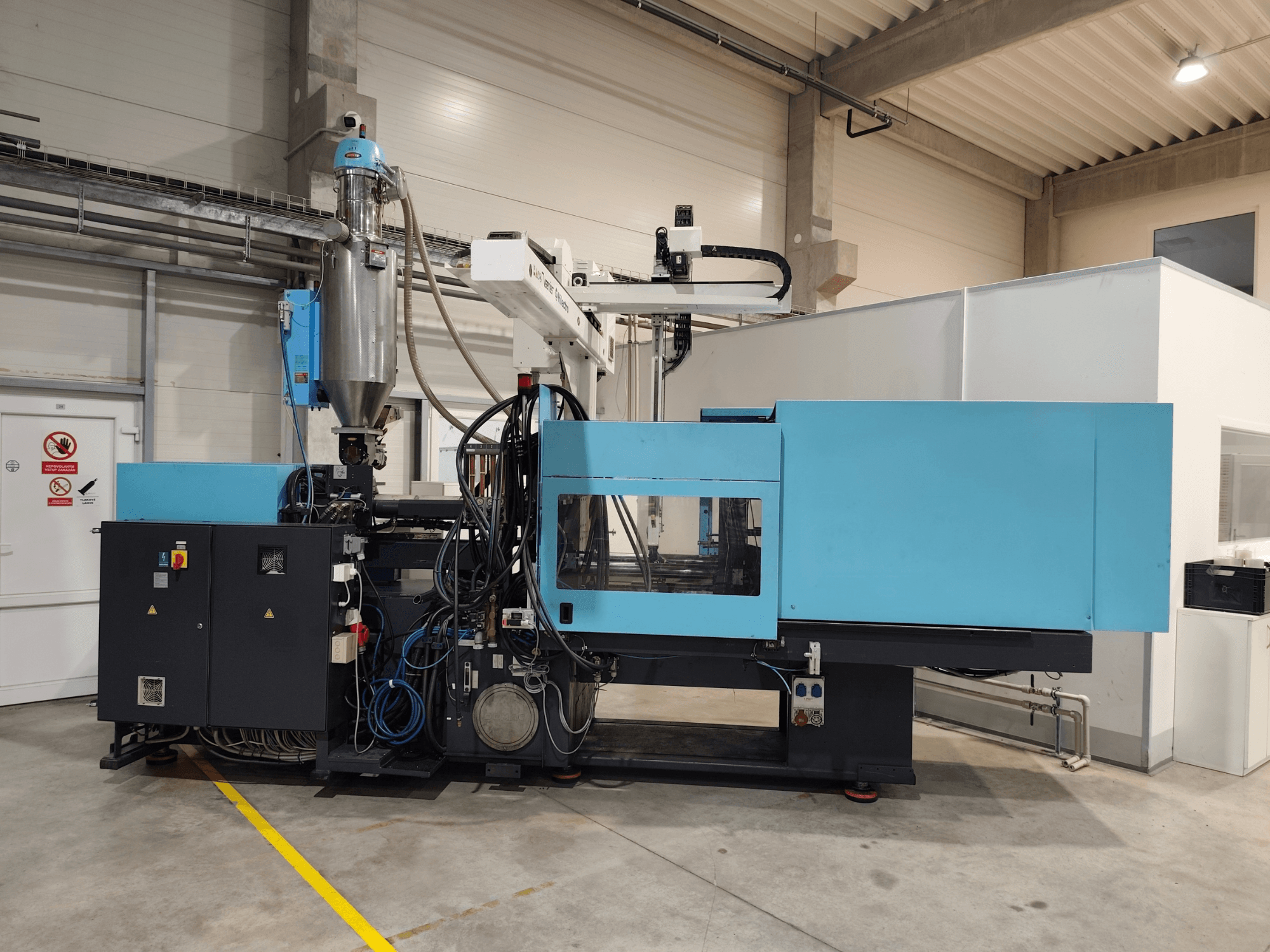 DEMAG Ergotech Extra 160-430 -hydraulisen ruiskuvalukoneen etunäkymä, jossa näkyvät ohjauspaneeli ja syöttösuppilo.