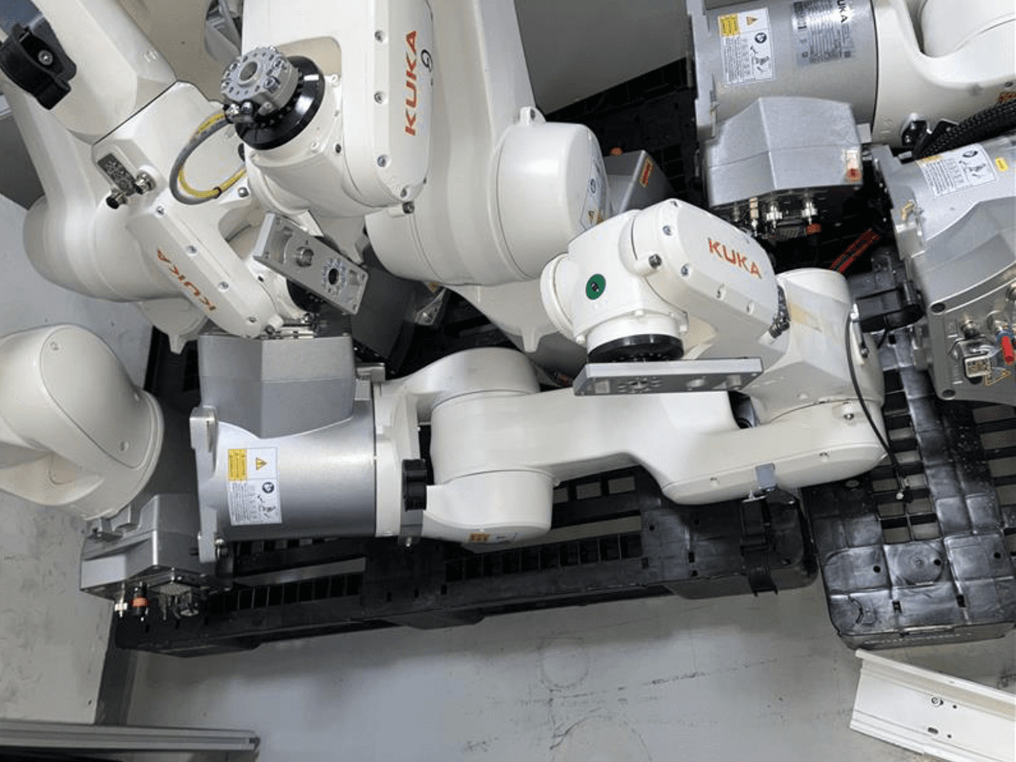 KUKA KR 10 R900-2 -robottivarsi ylhäältä katsottuna, jossa esitellään nivelnivelet ja käyttömoottorit teollisuusympäristössä.