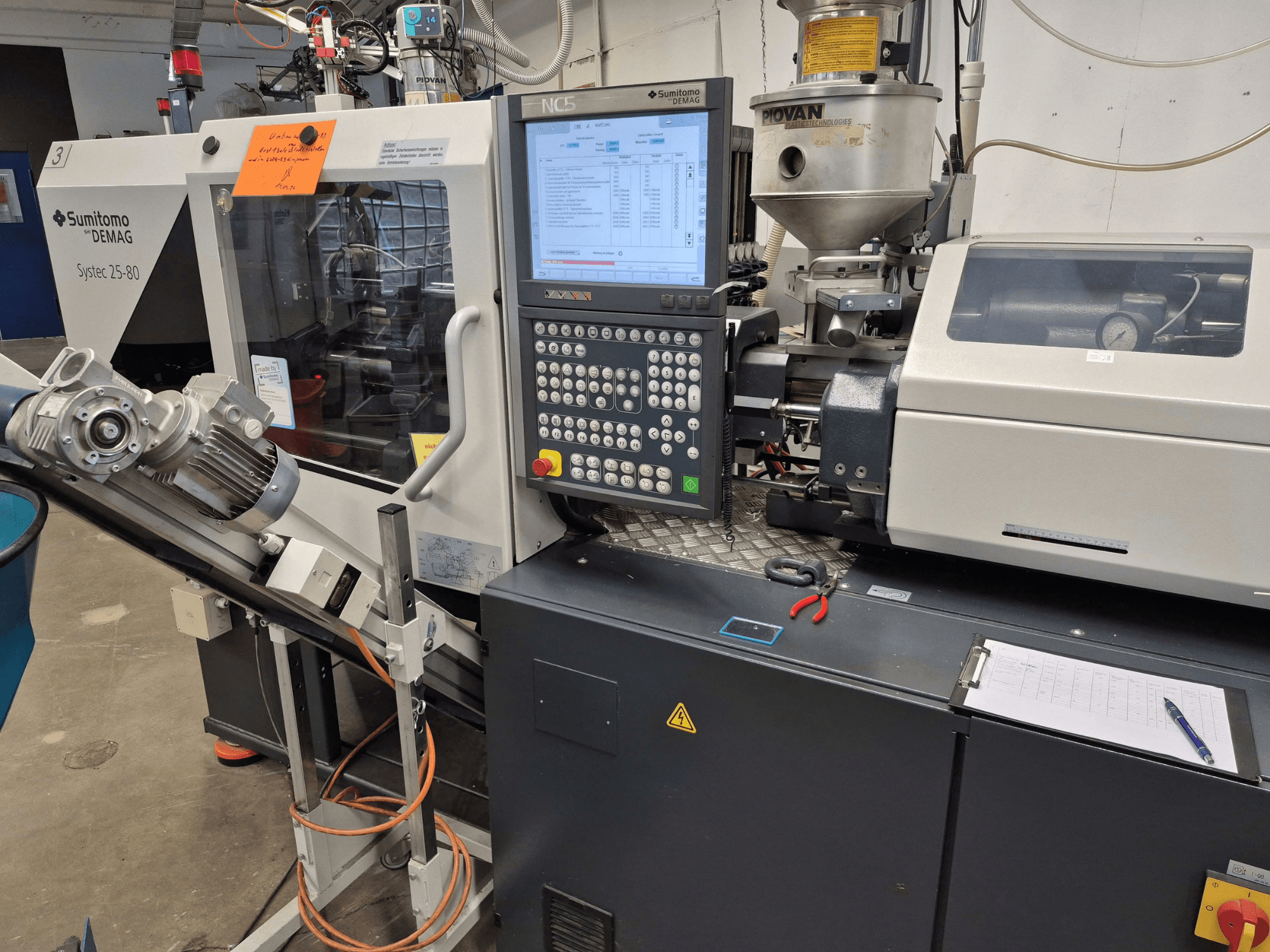 Hydraulinen ruiskuvalukone SUMITOMO SHI DEMAG Systec 25/320-80, etunäkymä, jossa näkyvät ohjauspaneeli ja syöttöjärjestelmä.