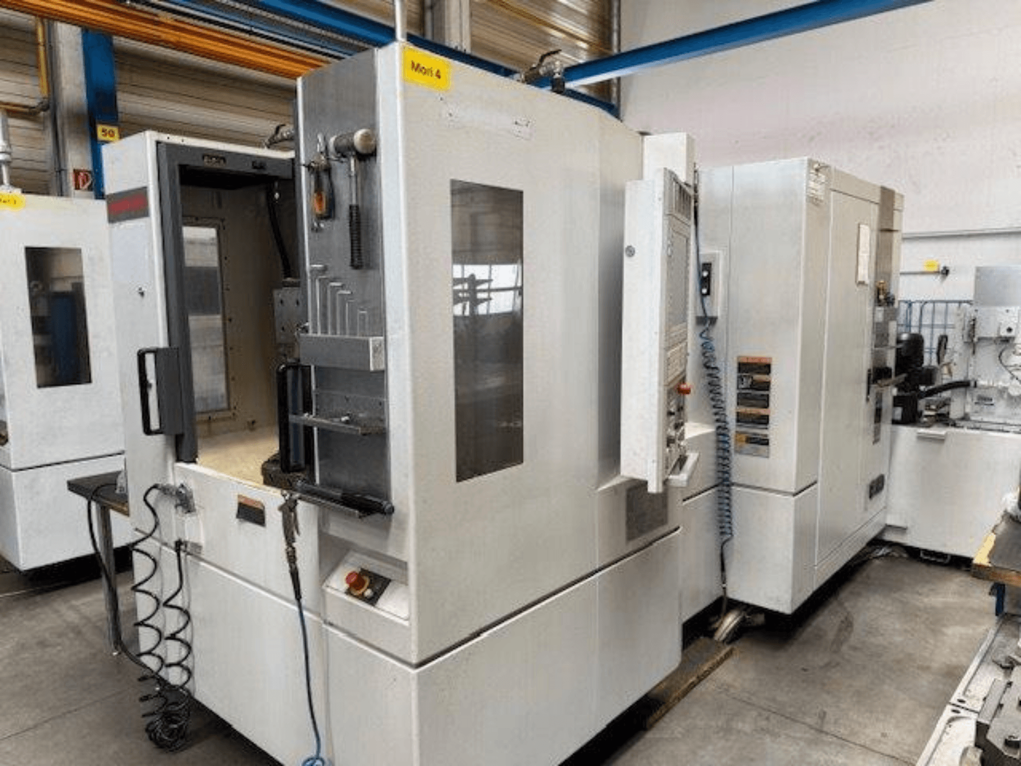 MORI SEIKI NH4000 DCG -vaakakoneistuskeskus edestä kuvattuna, avoin ovi ja ohjauspaneelin yksityiskohdat.