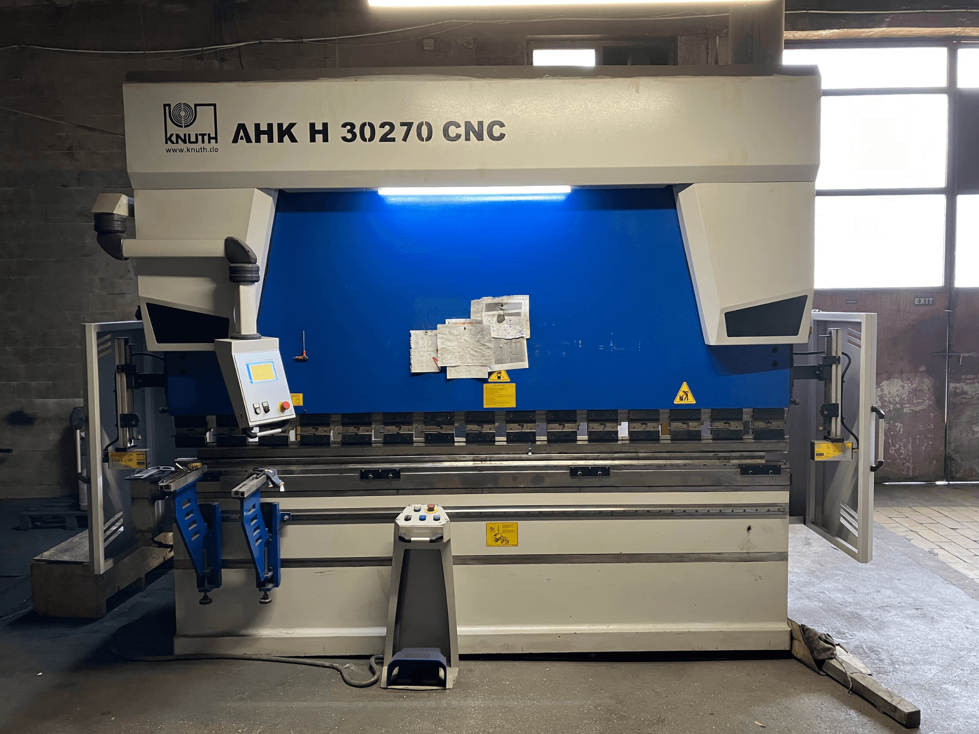 KNUTH AHK H 30270 CNC-taivutuskone työpajassa, etunäkymä, jossa näkyy ohjauspaneeli ja sinivalkoinen ulkoasu, sivuluukku auki.