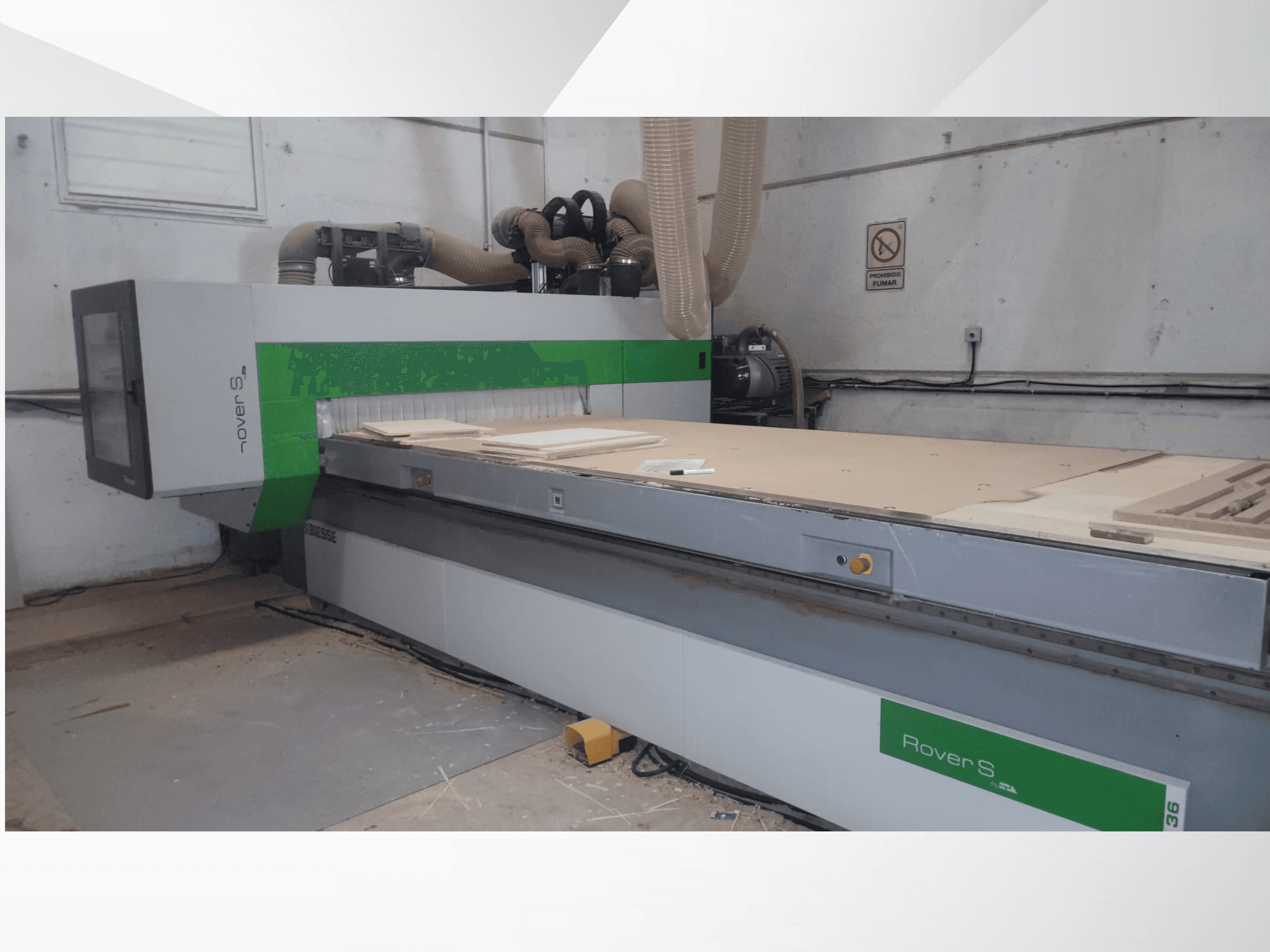 Etukuva Biesse Rover S CNC-koneesta, jossa on suuri työtaso puupaneeleilla ja pölynpoistoletkuilla.