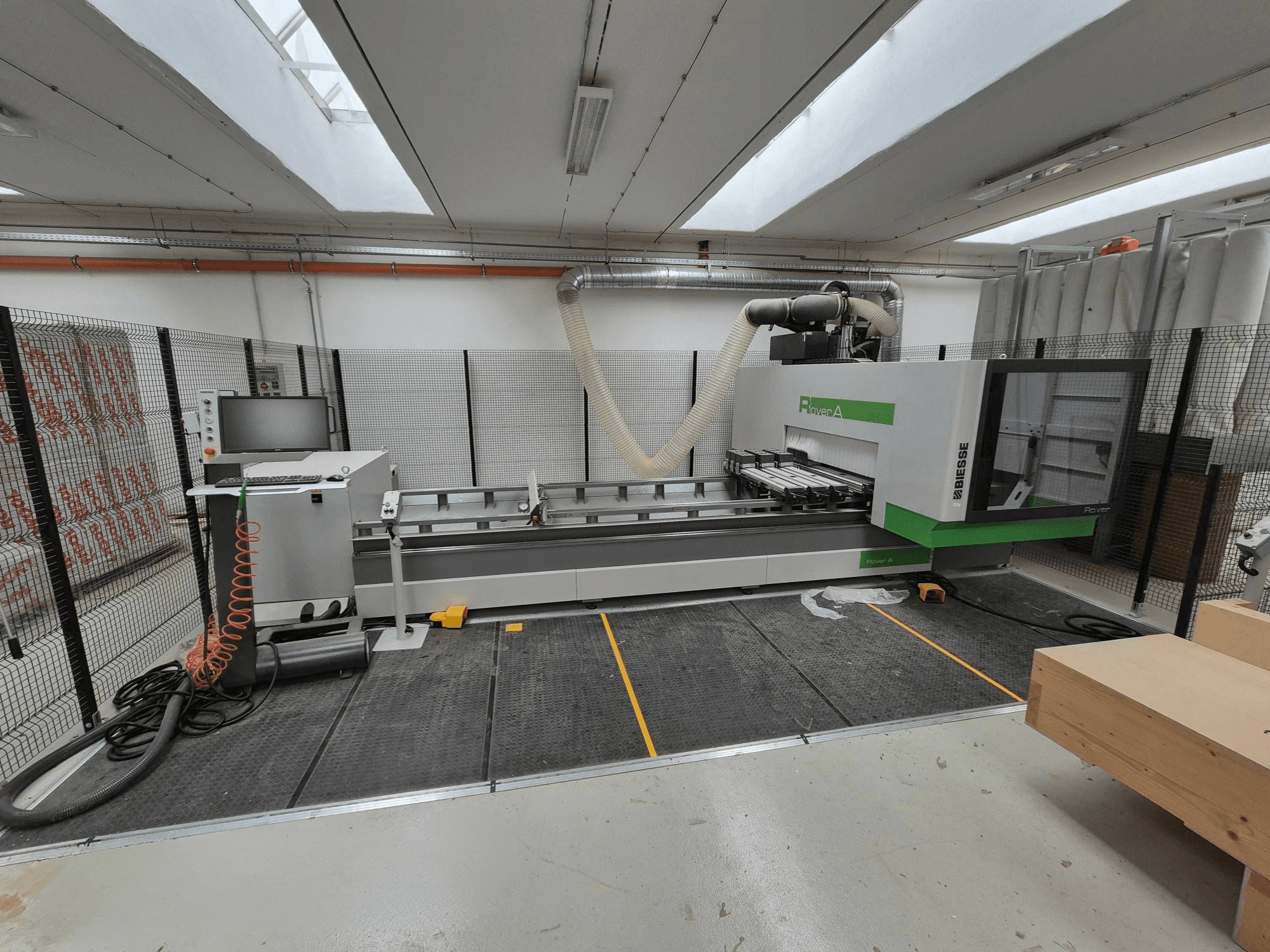 Biesse Rover CNC-kone työpajassa, etukuva. Siinä on ohjauspaneeli, tyhjiöjärjestelmä ja työtaso.