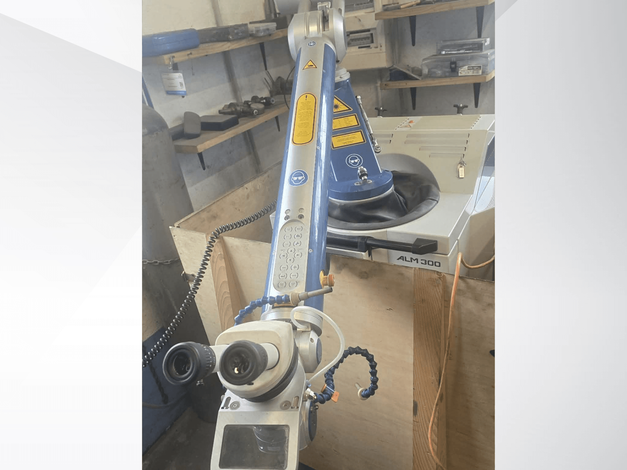 ALPHA LASER ALM 300 -laserhitsauskoneen etunäkymä, jossa näkyvät robottivarsi, optiset linssit ja ohjauspaneeli.