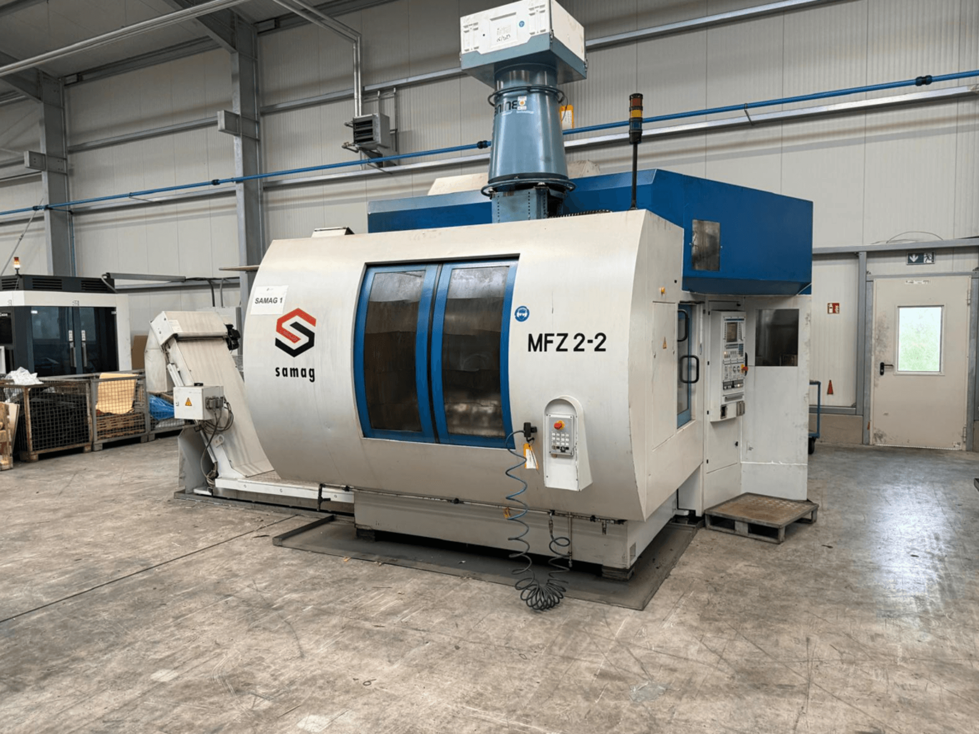 Samag MFZ 2-2 -työstökone, etukuva, jossa näkyy ohjauspaneeli ja sininen yläosa, jossa on turvalaitteet teollisuusympäristössä.