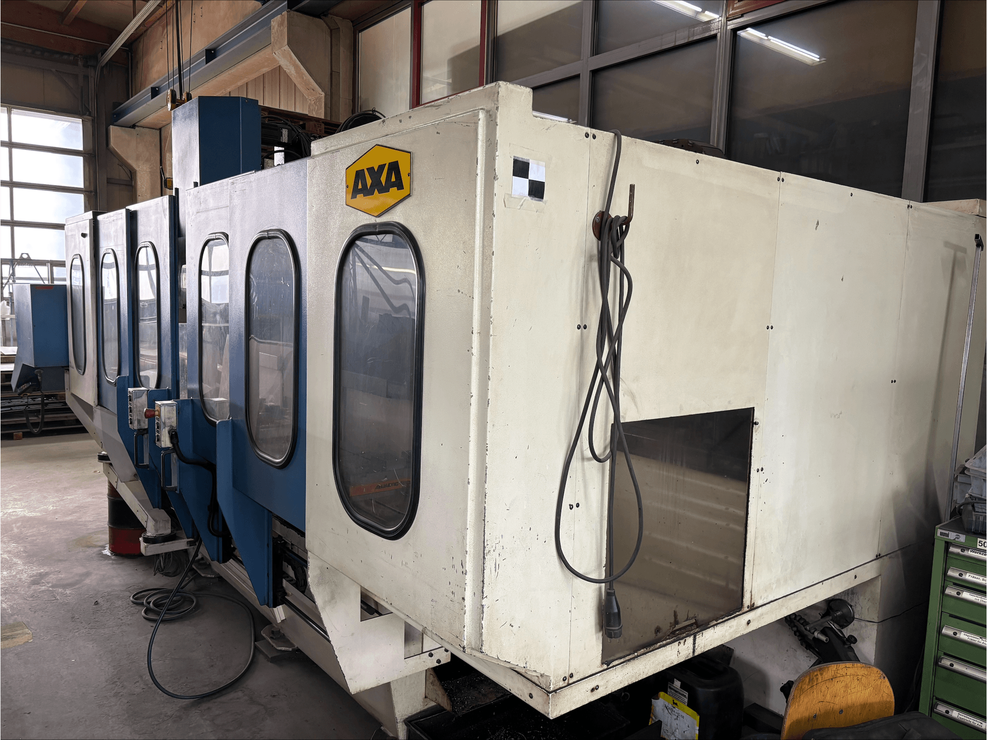 AXA VSC-1-M/C -pystytyöstökeskus, etukuva, jossa on suuri valkoinen kaappi ja sininen ohjauspaneeli.