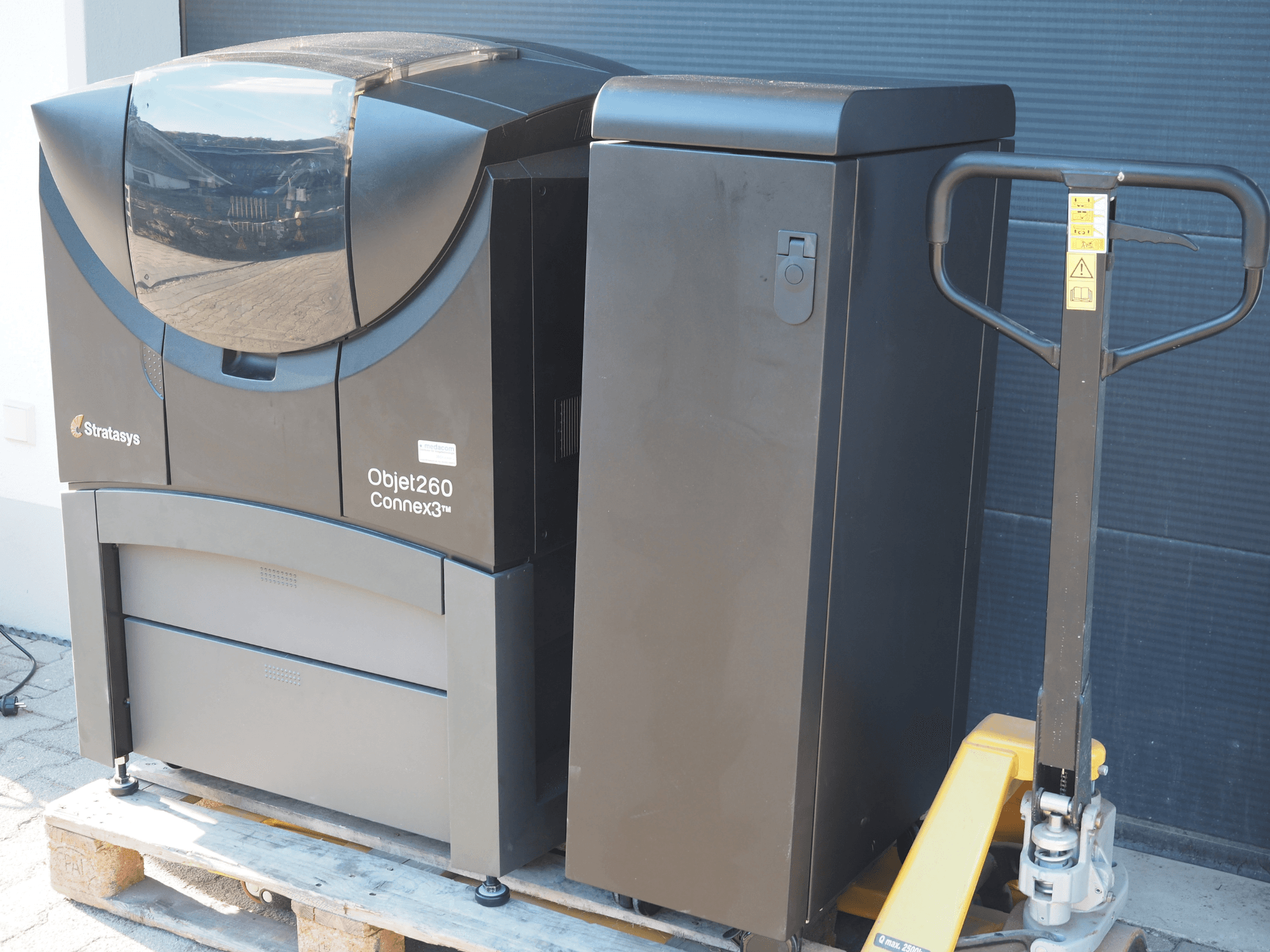Stratasys Objet260 Connex3 -muovinen 3D-tulostin, sivukuva, jossa on kompakti muotoilu, ohjauspaneeli ja liitetty materiaalisäiliö.