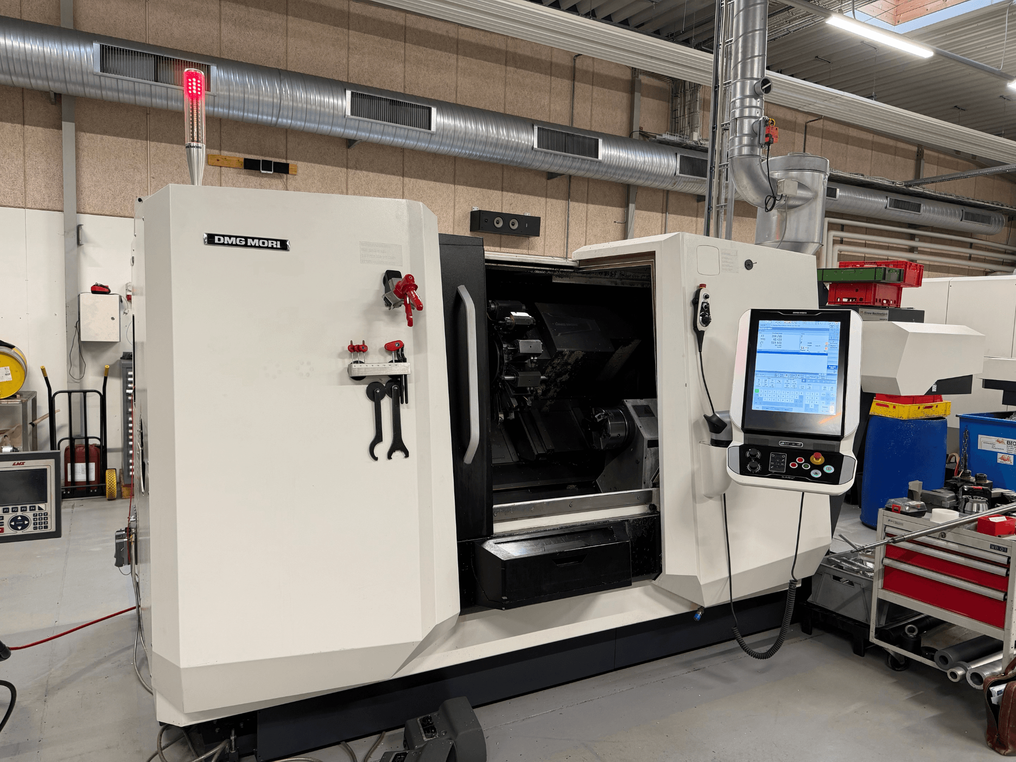 DMG MORI CLX 450 V6 -vaakasuora sorvi, etunäkymä, jossa näkyvät ohjauspaneeli, hätäpysäytyspainike ja turvavalo.