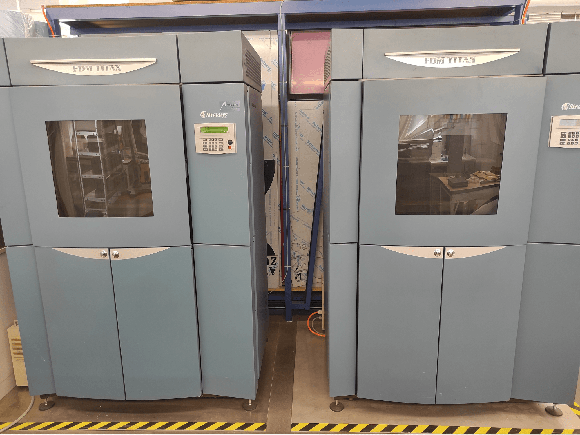 Stratasys FDM TitanTI T0031 -muovisen 3D-tulostimen etunäkymä; siinä on näyttöpaneeli ja läpinäkyvä ikkuna.