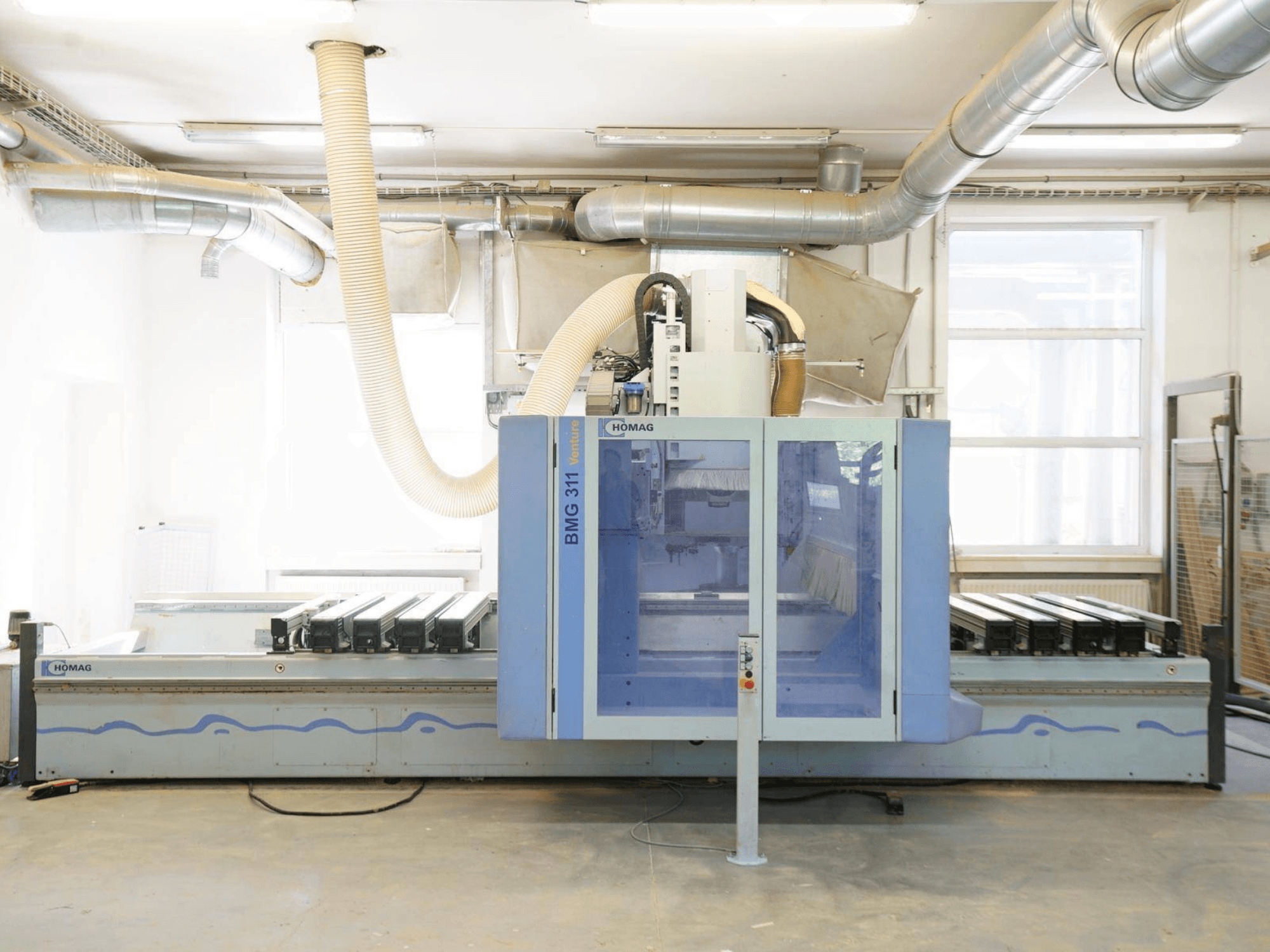 CNC-puunkäsittelykeskus HOMAG V BMG 311/42/F/K, etunäkymä; varustettu suurella työpöydällä ja pölynpoistojärjestelmällä.