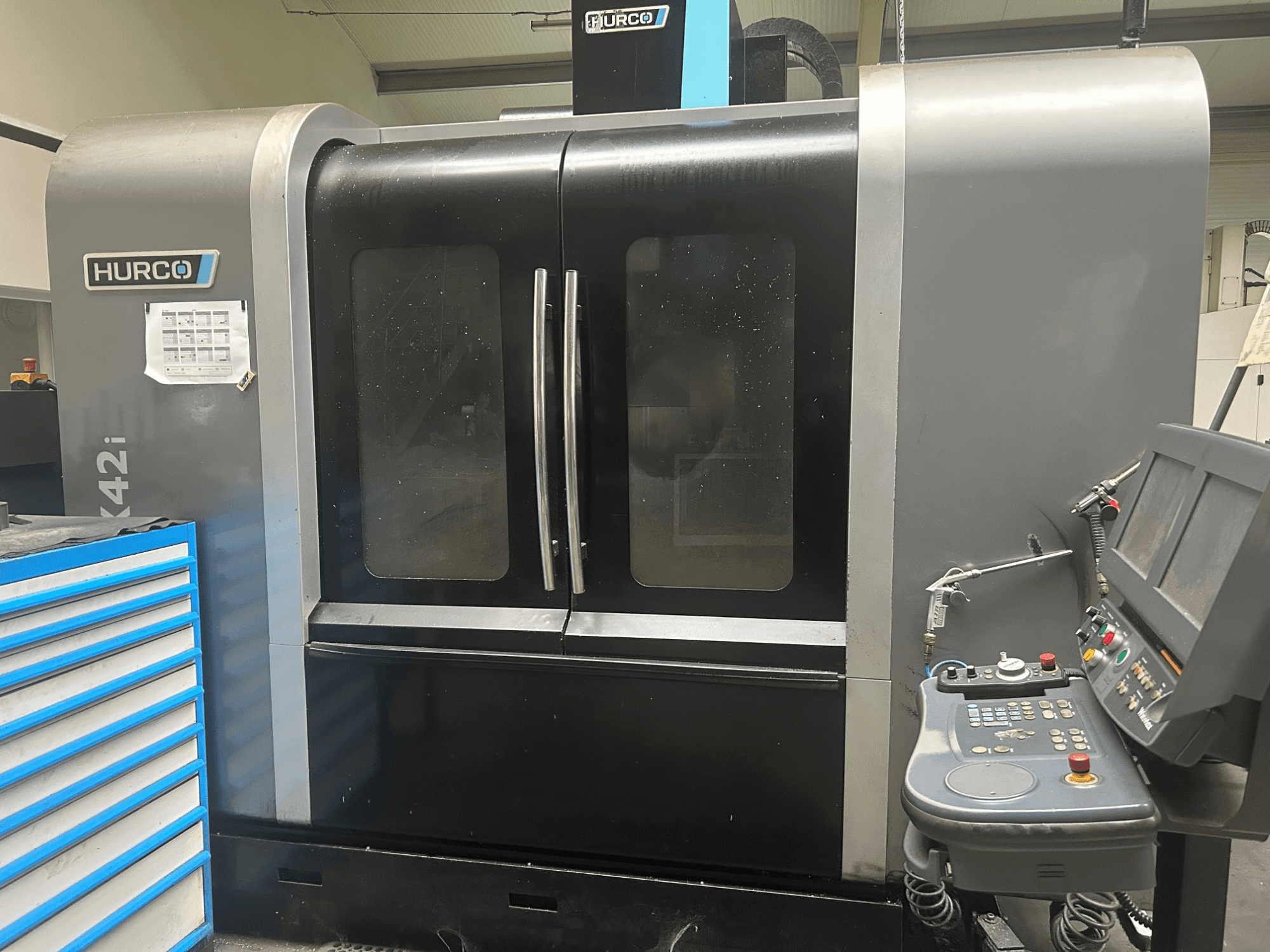 Hurco VMX42i CNC-kone, etukuva, jossa ohjauspaneeli sivulla, kaksoisovet ja näkyvät tekniset yksityiskohdat.