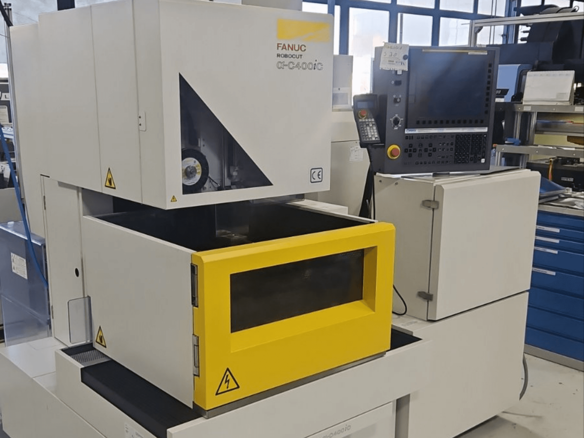 FANUC Robocut alpha-C400iC -upotus-EDM-kone edestä katsottuna; siinä on keltainen työkappaleosasto ja ohjauspaneeli.