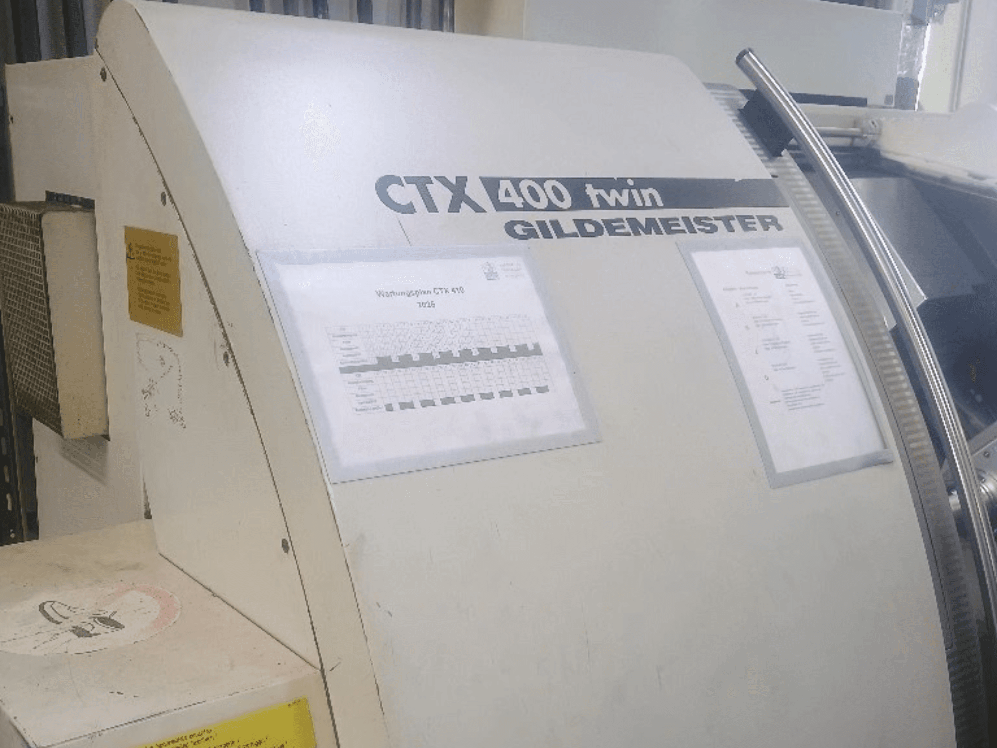 Gildemeister CTX 400 -kaksoisvaakasuora sorvi, etunäkymä, jossa näkyvät käyttöpaneelit ja tekninen dokumentaatio.