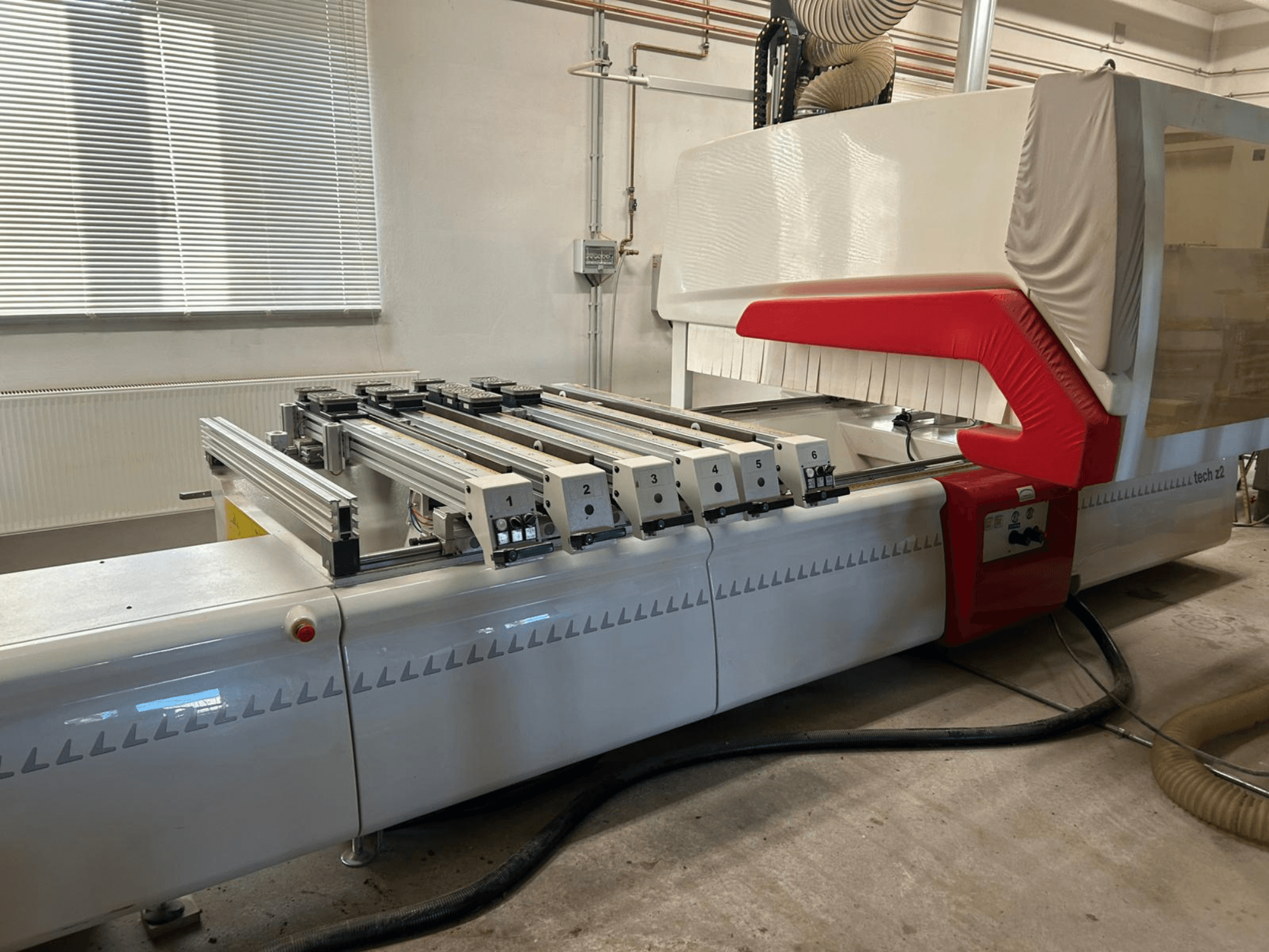 SCM TECH Z2-27-C puunporauskone, sivukuva, jossa näkyy ohjauspaneeli ja kiskot, punainen ja valkoinen muotoilu.