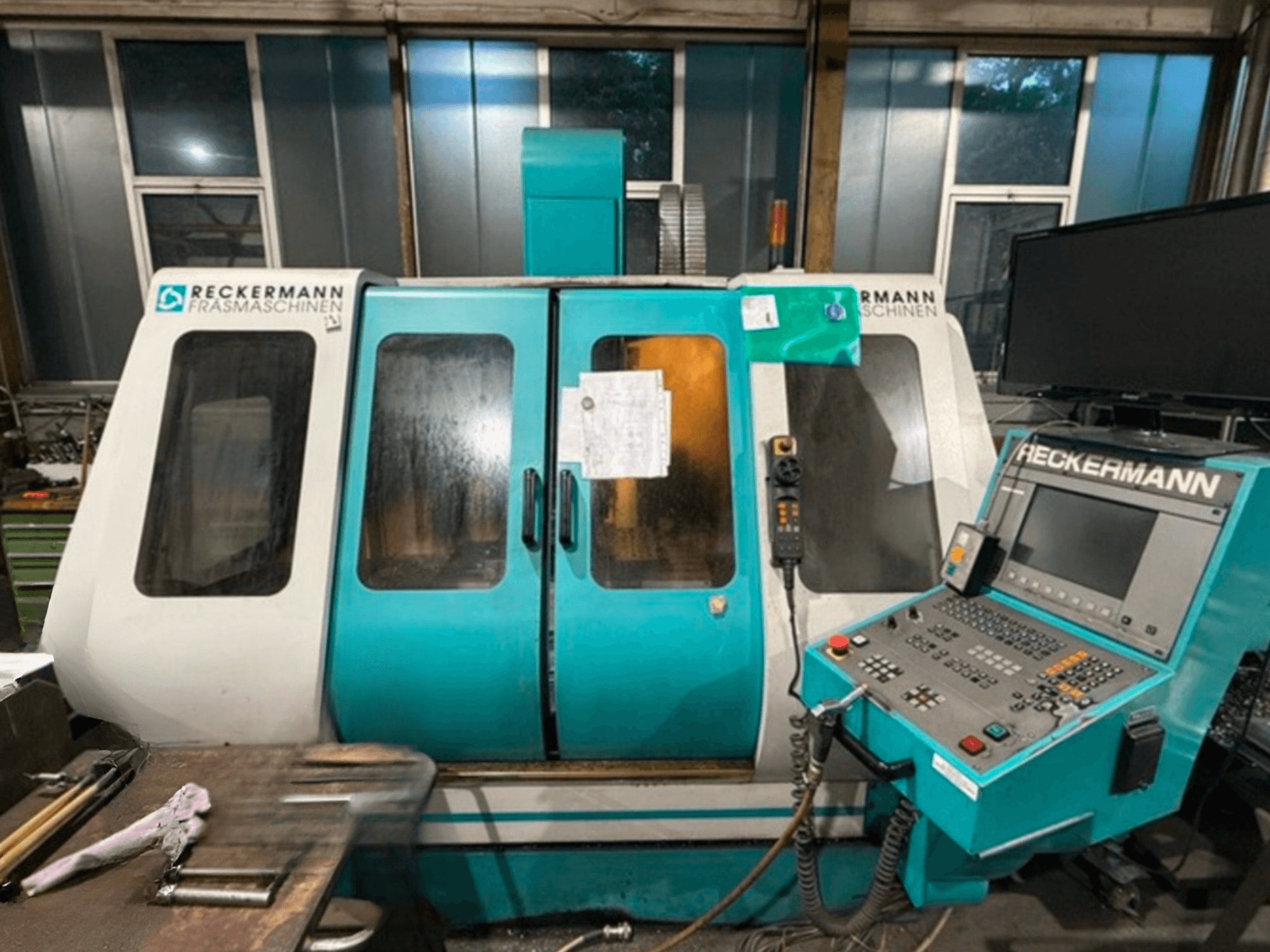 RECKERMANN VMC 850 Universal-työstökeskus, etukuva, jossa näkyy ohjauspaneeli ja lasiovet.