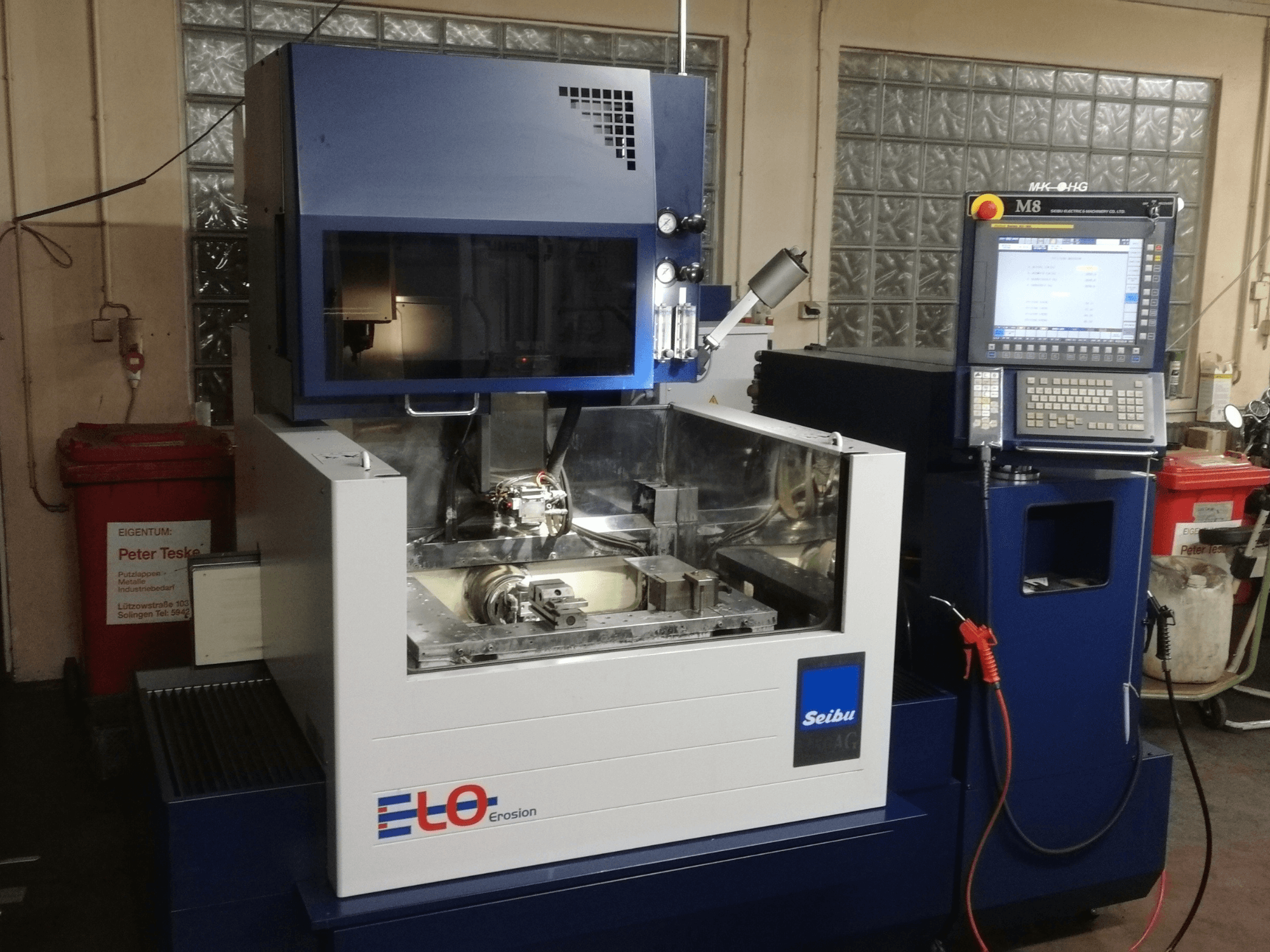 ELO Seibu -eroosiokone edestä katsottuna, jossa on ohjauspaneeli ja näkyvä työalue, jossa on metalliosia.